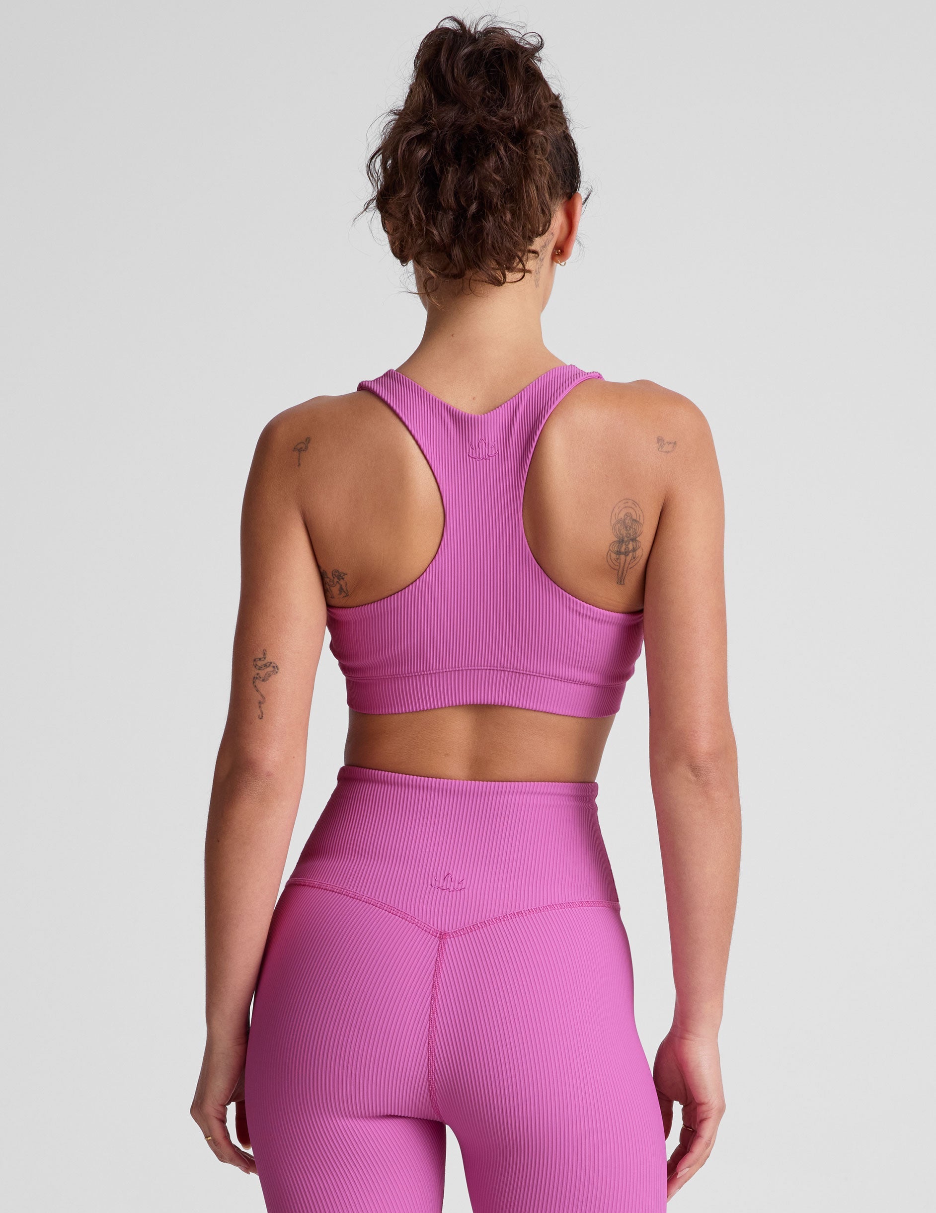 pink medium support racerback bra with a scoop neckline​, overlapping hemband detail​, is lined with performance lining and powermesh in between​, and has removable bra pads​. 