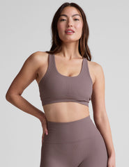 brown medium support racerback bra with a scoop neckline​, overlapping hemband detail​, is lined with performance lining and powermesh in between​, and has removable bra pads​. 