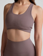 brown medium support racerback bra with a scoop neckline​, overlapping hemband detail​, is lined with performance lining and powermesh in between​, and has removable bra pads​. 