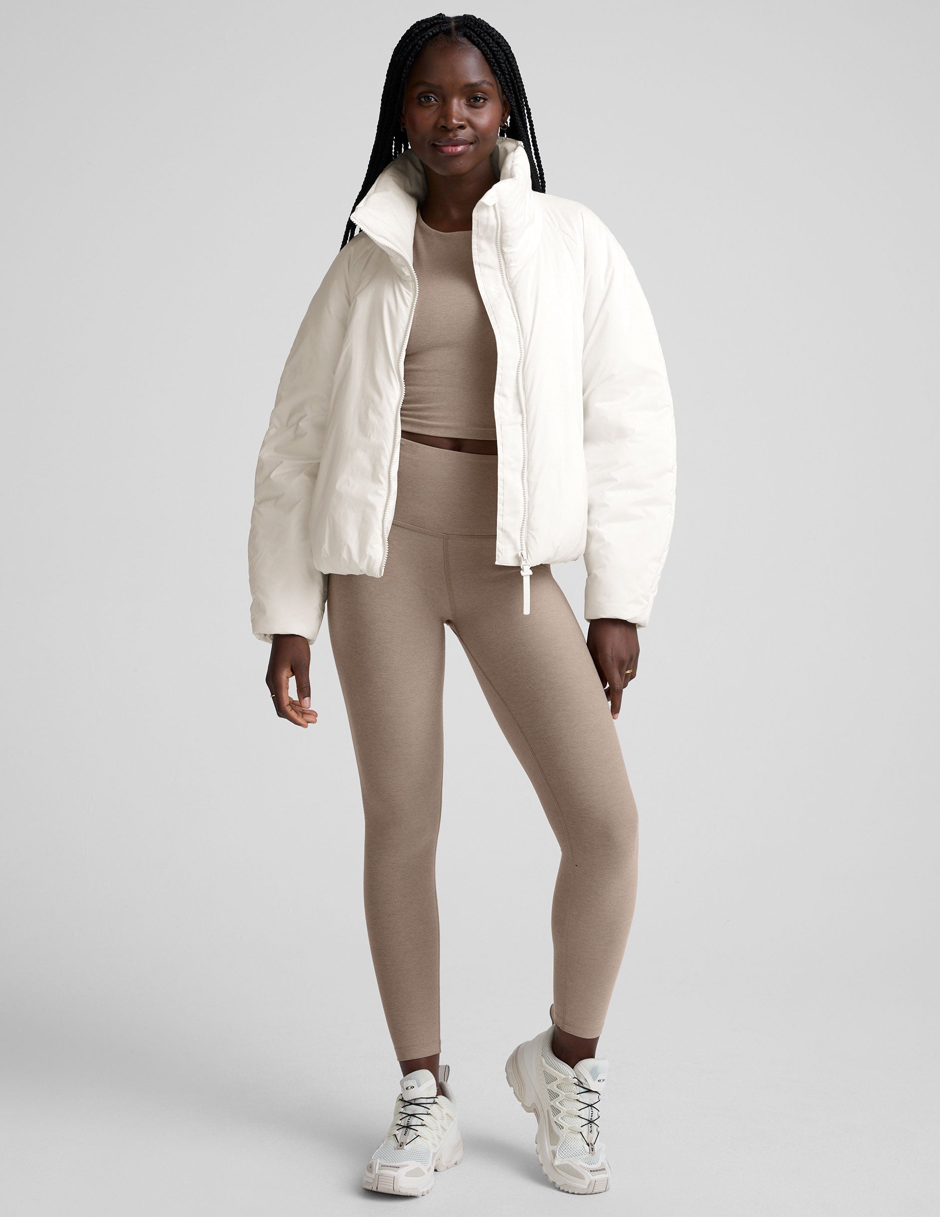 model wearing a white puffer jacket against a plain background.