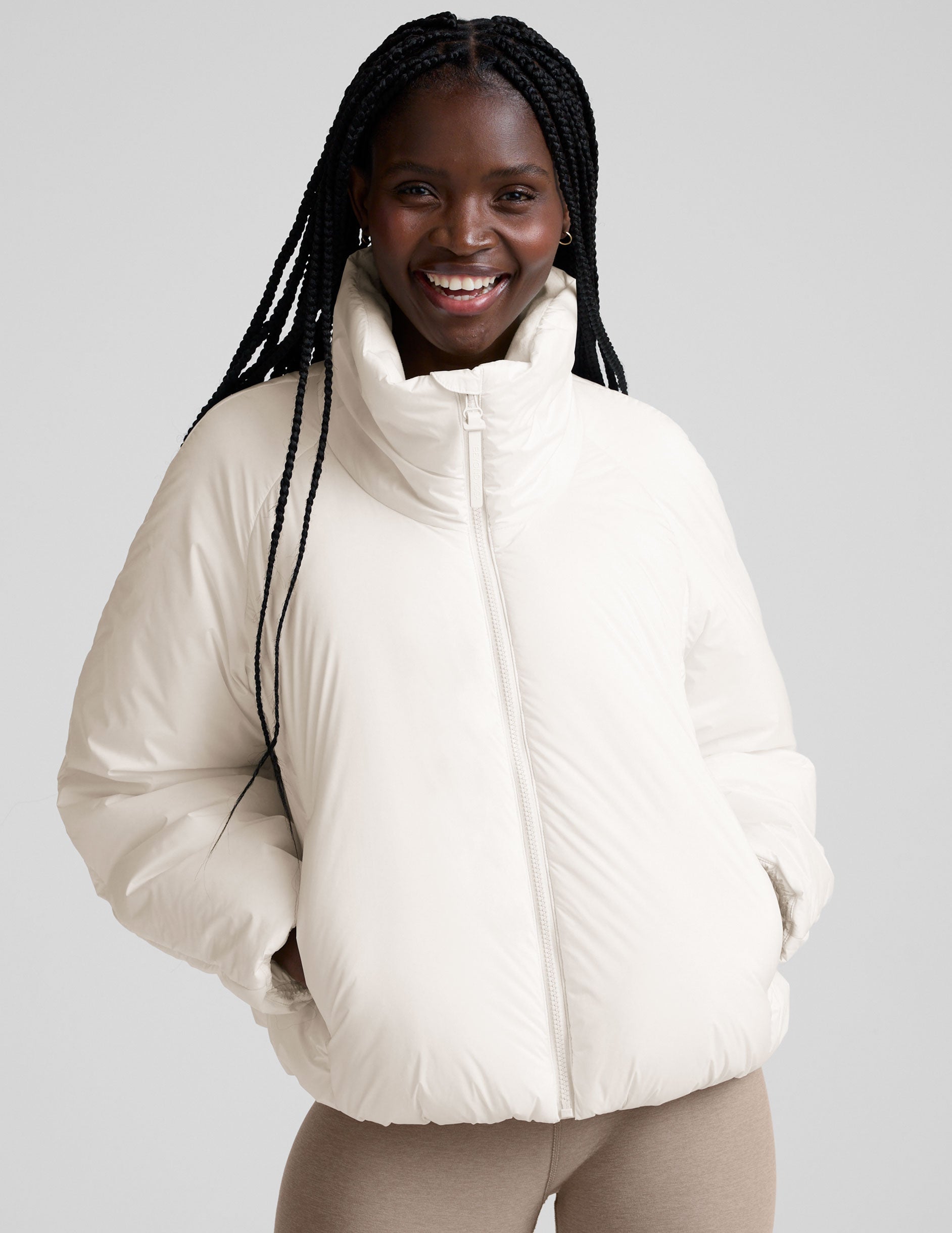 model wearing a white puffer jacket against a plain background.
