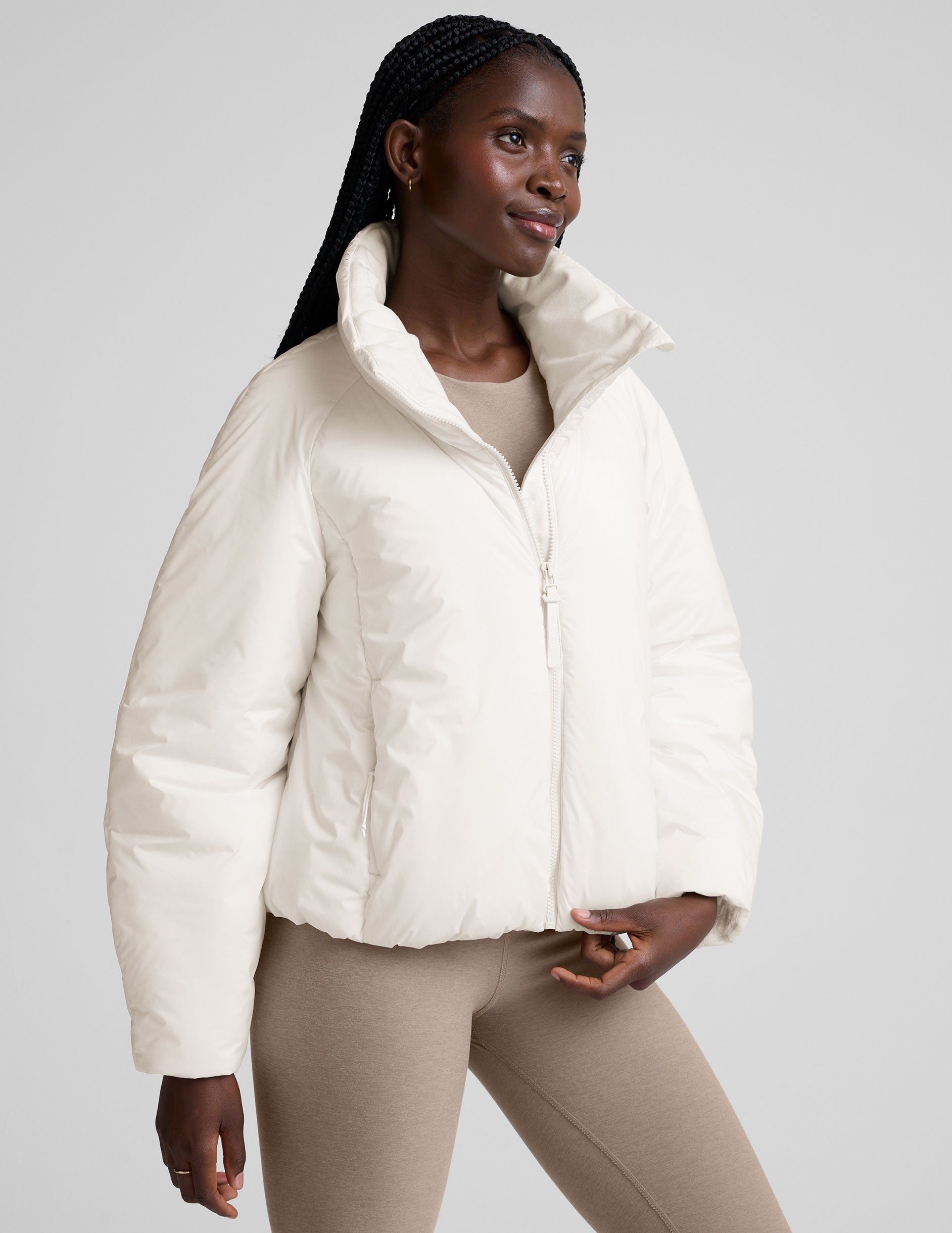 model wearing a white puffer jacket against a plain background.