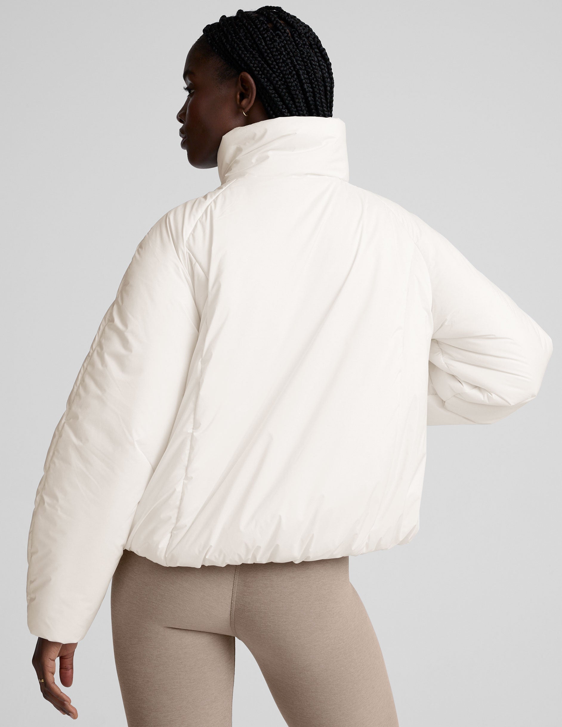 model wearing a white puffer jacket against a plain background.