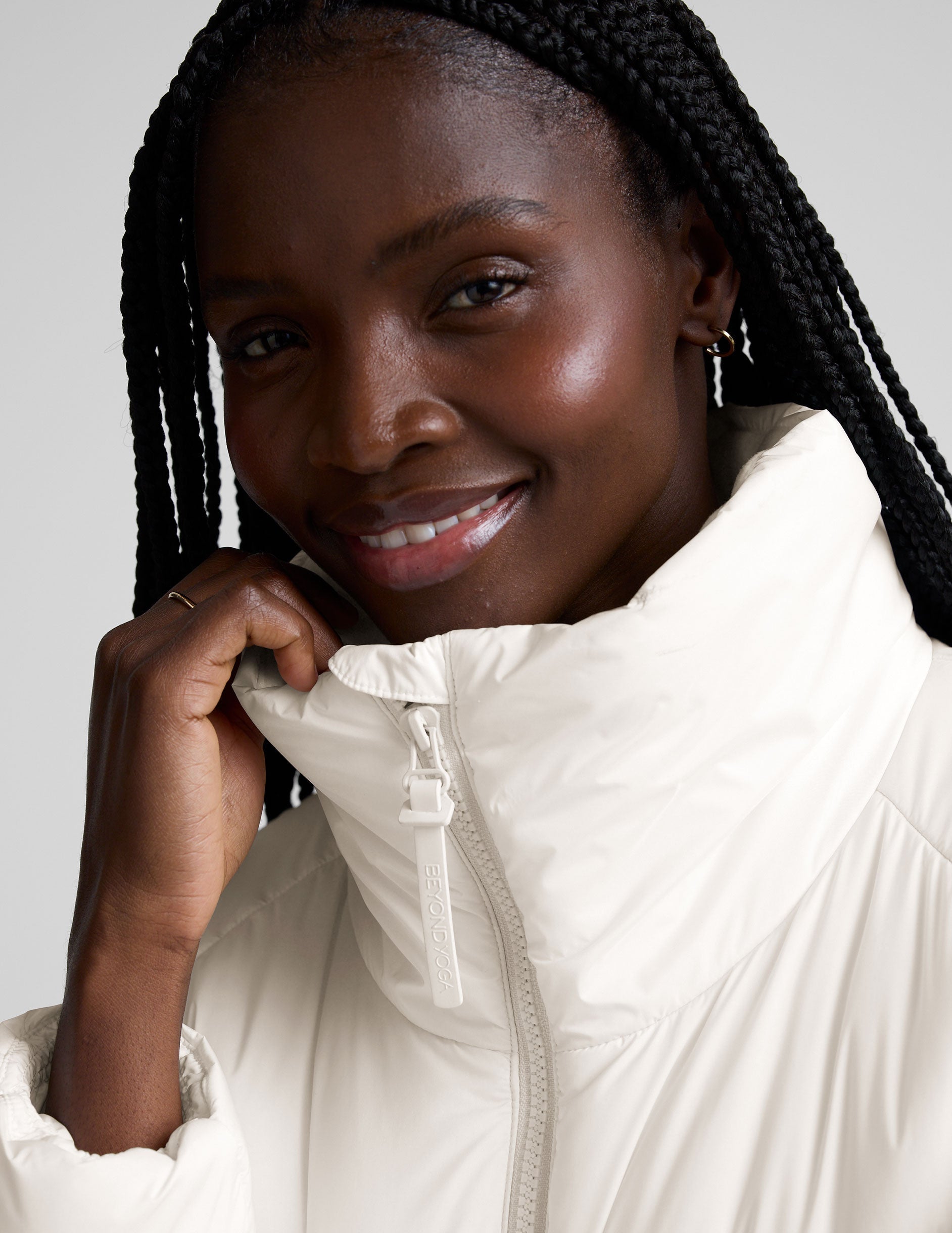 model wearing a white puffer jacket against a plain background.