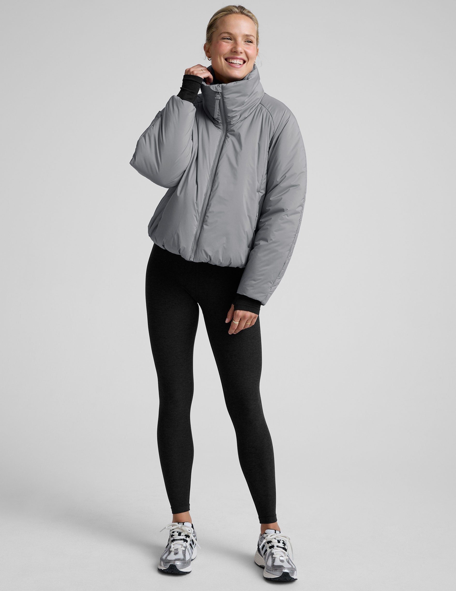 model wearing a gray puffer jacket on a light gray background.