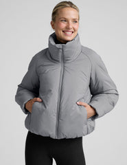 model wearing a gray puffer jacket on a light gray background.
