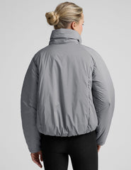 model wearing a gray puffer jacket on a light gray background.