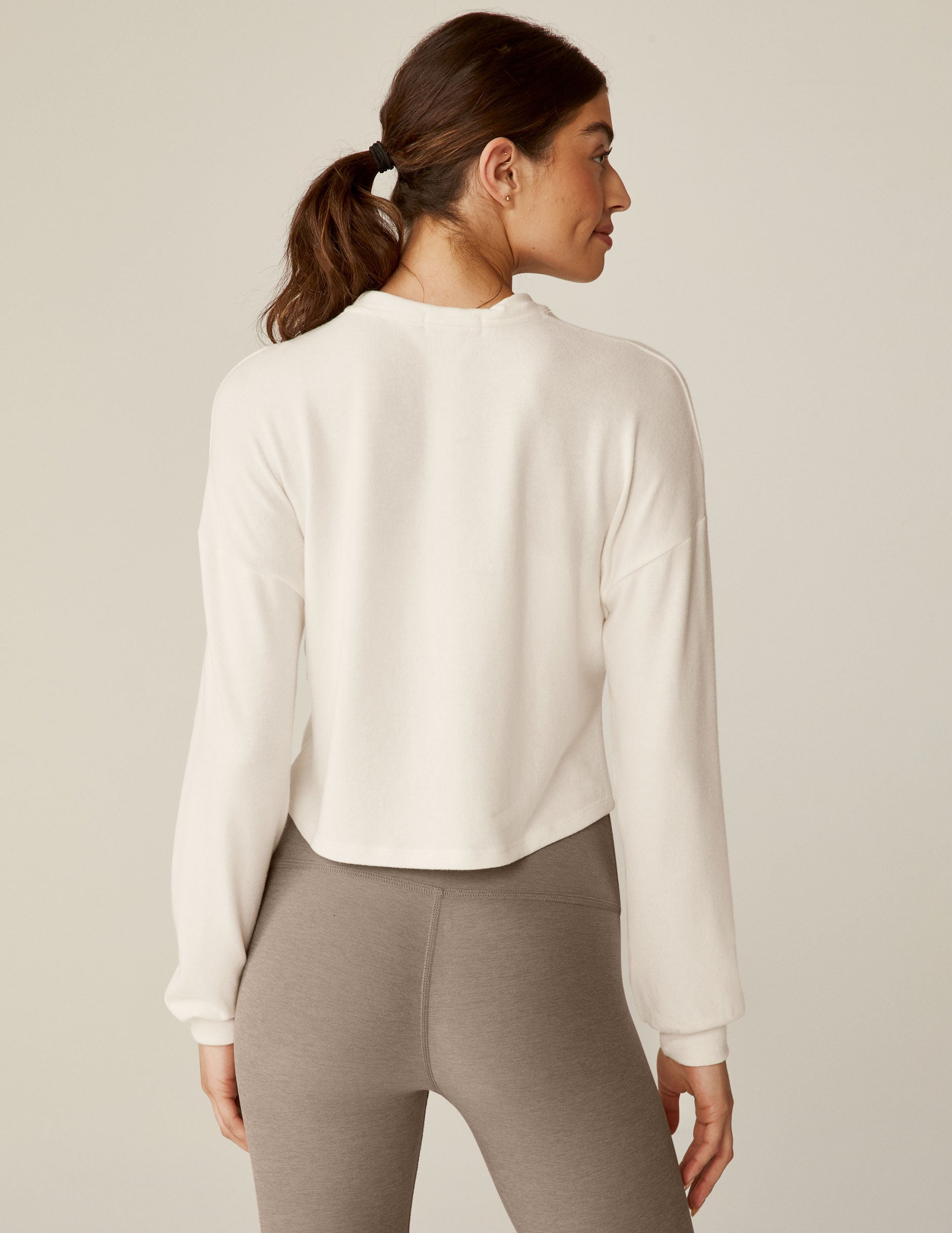 white crew neck relaxed fit cropped pullover with a detailing twist at front waist.