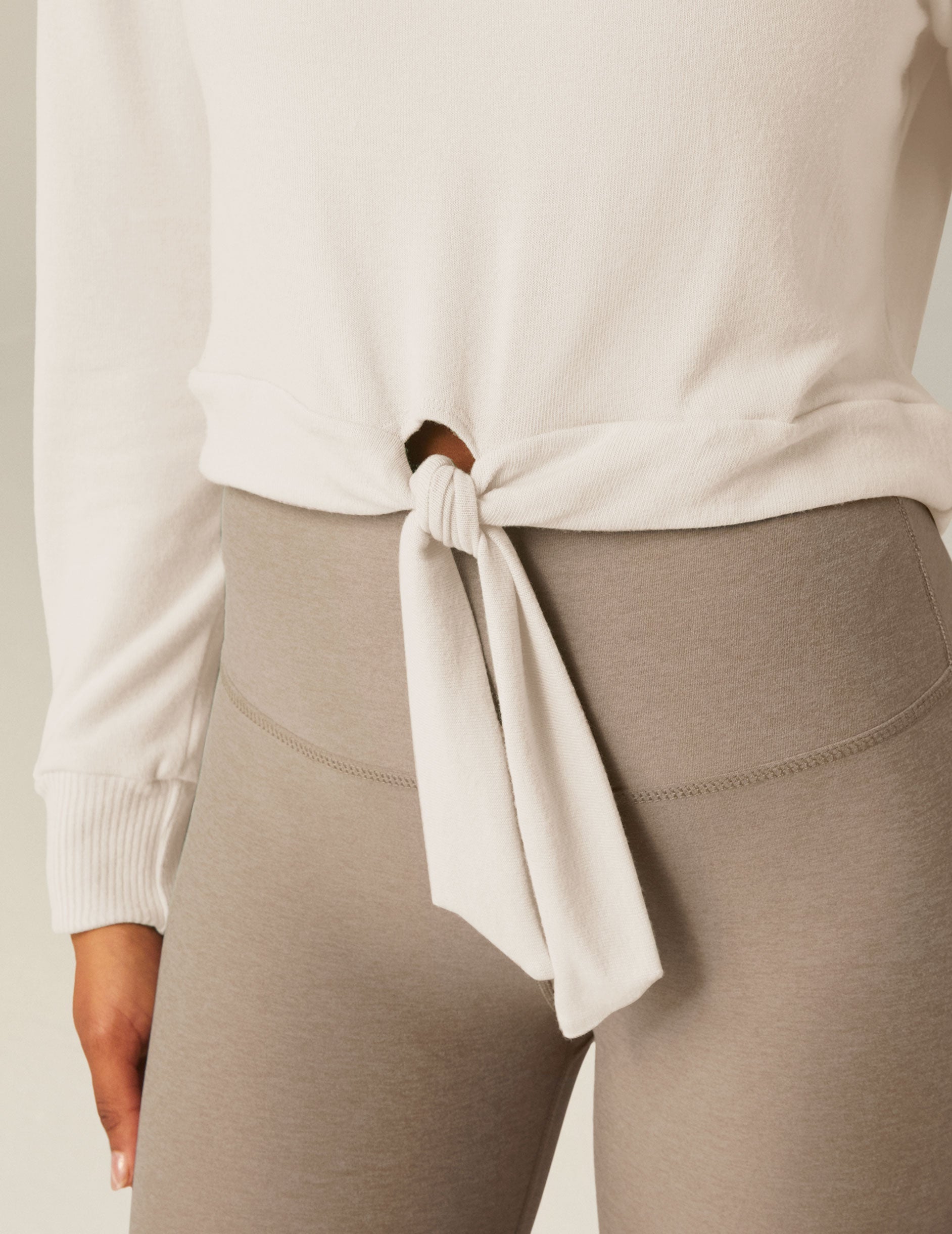 white scoop neck cropped pullover with a front tie detail.