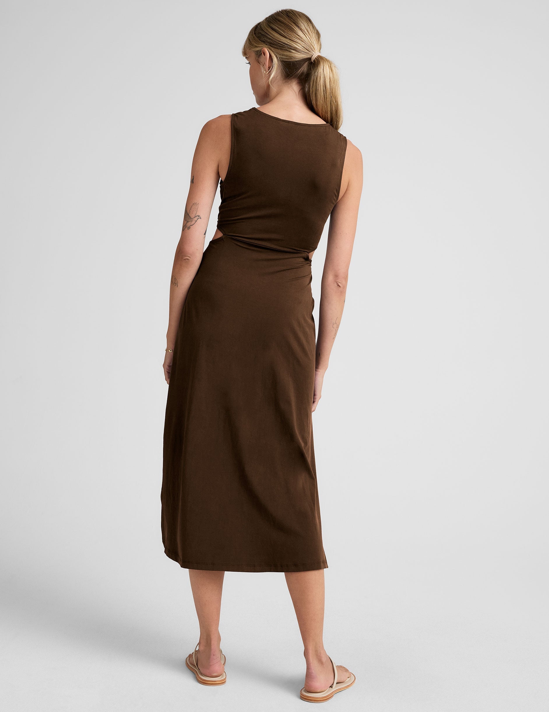 brown midi length tank dress with side slits and cutouts at waist.