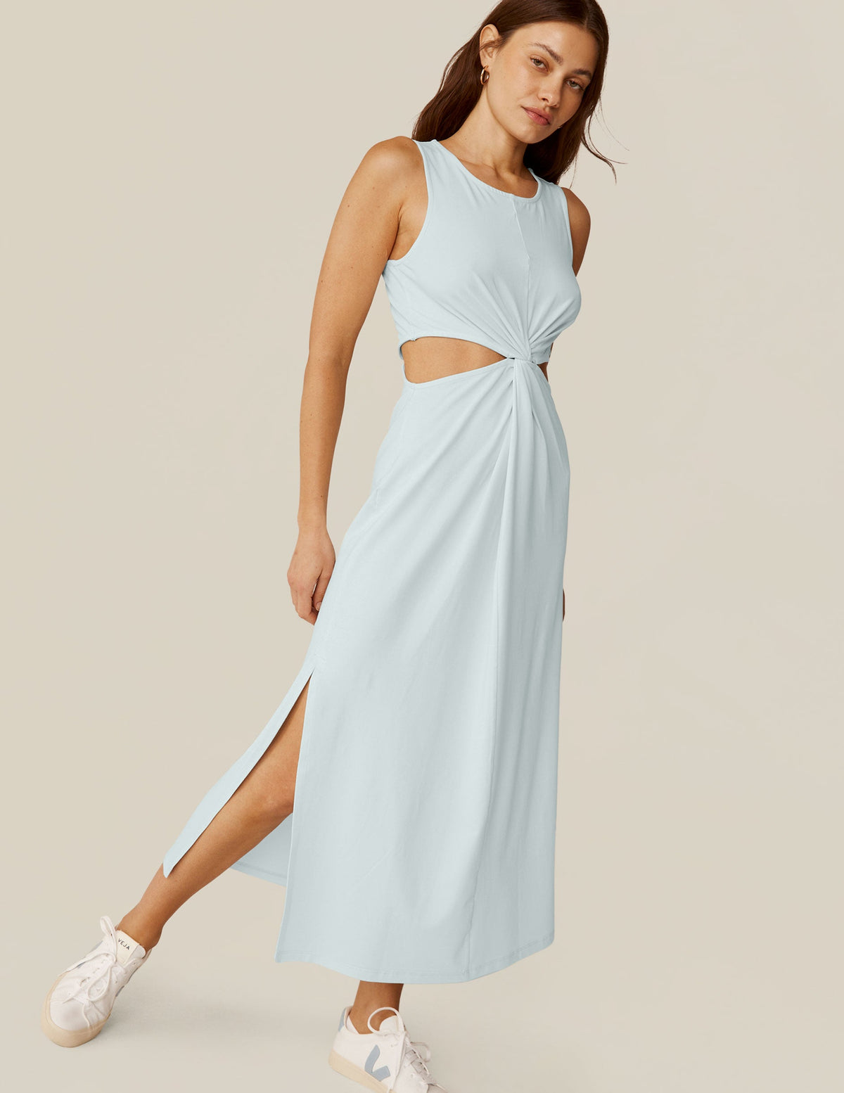model is wearing a blue tank top maxi dress with a twist detailing and side cutouts.