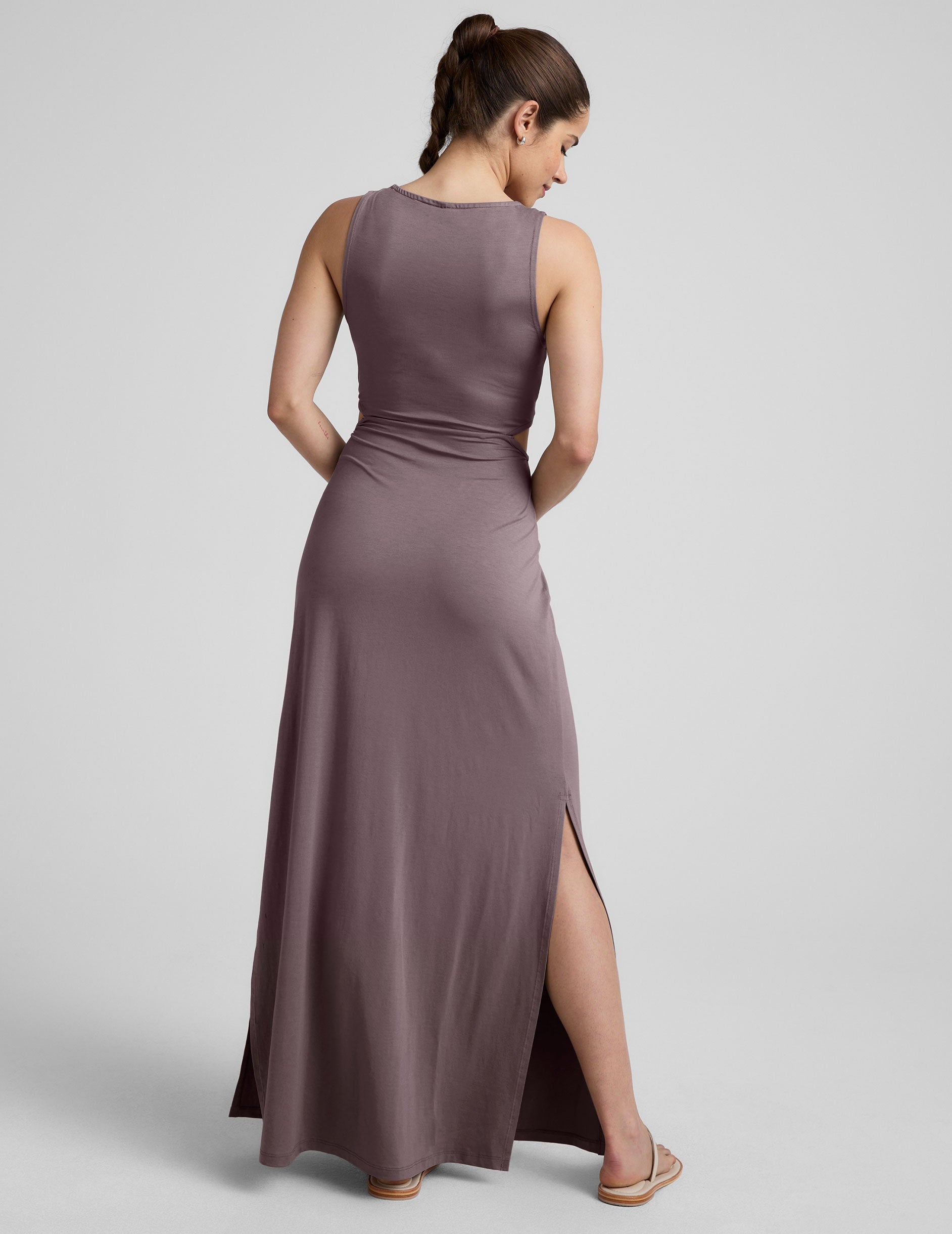 brown v-neck tank maxi length dress with cutouts at the waist.