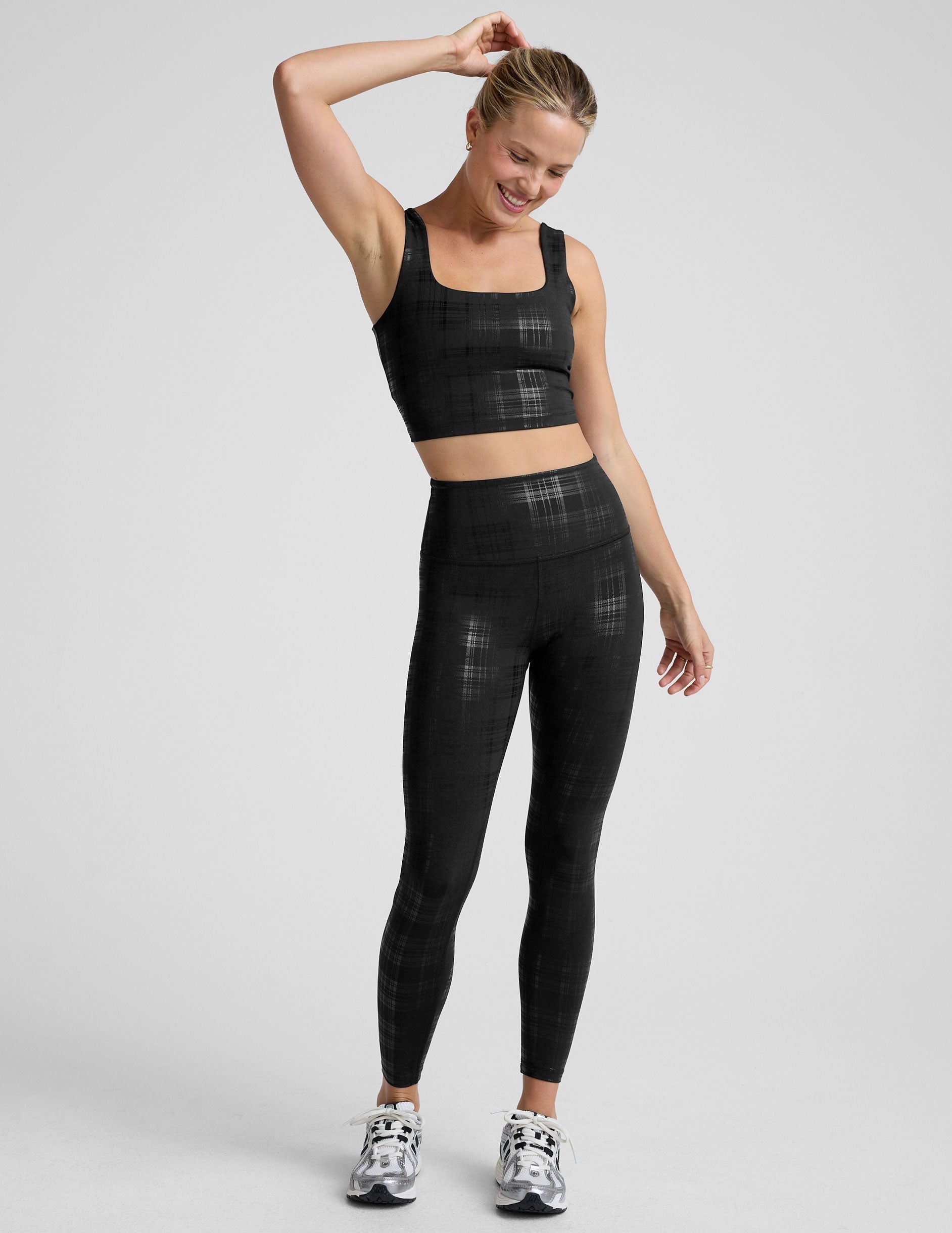 model wearing a black plaid foil cropped tank and black plaid foil leggings on a white background.