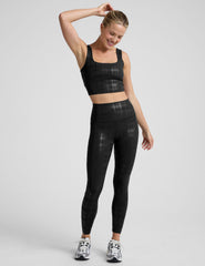 model wearing a black plaid foil cropped tank and black plaid foil leggings on a white background.