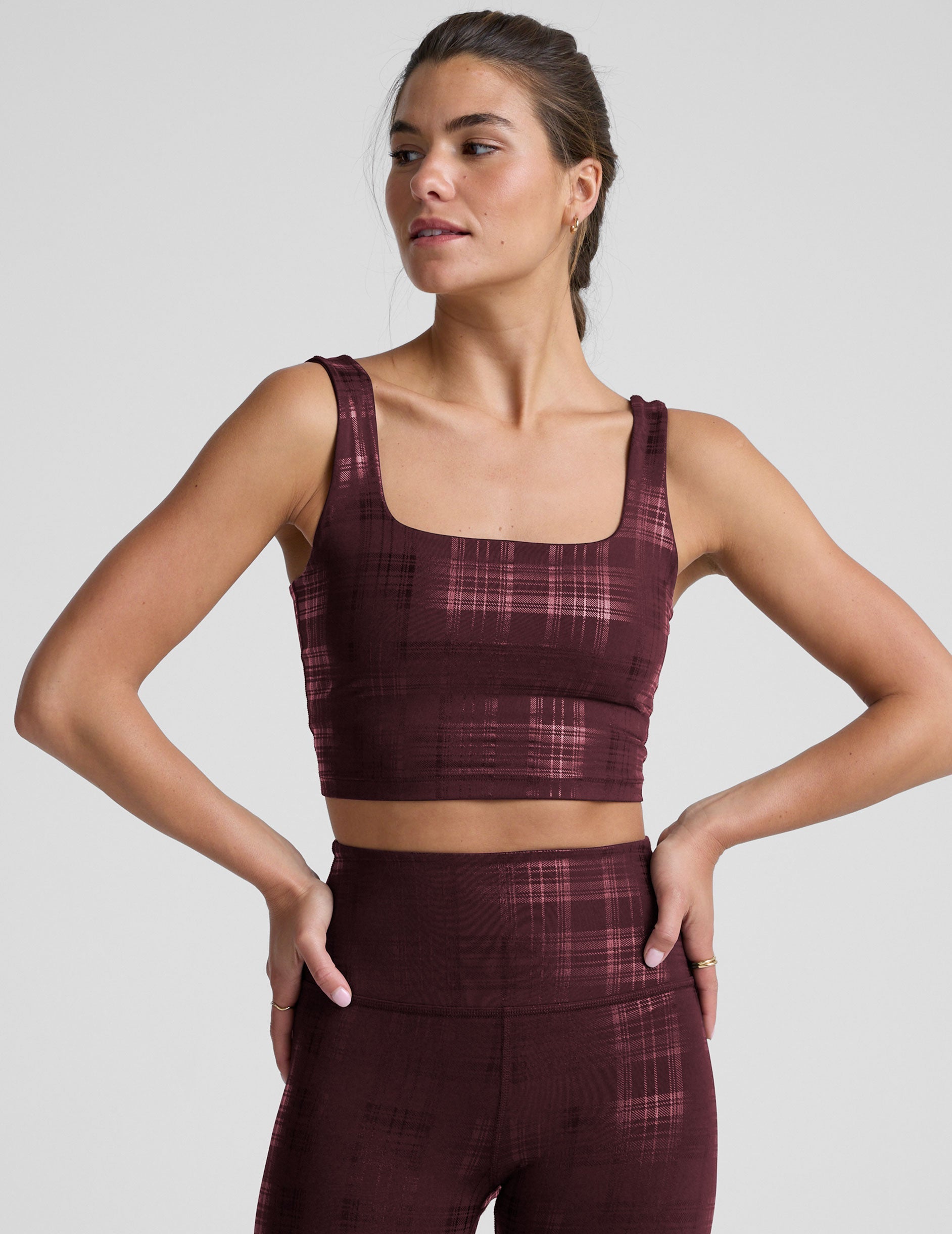 model wearing a red plaid foil printed square neck cropped tank top and matching leggings against a plain background.