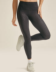 black high-waisted midi length leggings with a shimmering heart pattern.