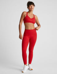 red high-waisted midi length leggings with a shimmering heart pattern.