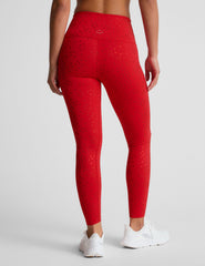 red high-waisted midi length leggings with a shimmering heart pattern.
