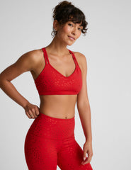 red bra top with a soft v neckline, double crossover straps and a shimmering heart pattern. 