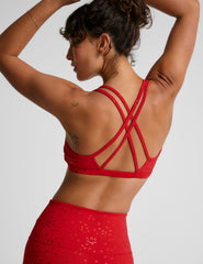 red bra top with a soft v neckline, double crossover straps and a shimmering heart pattern. 