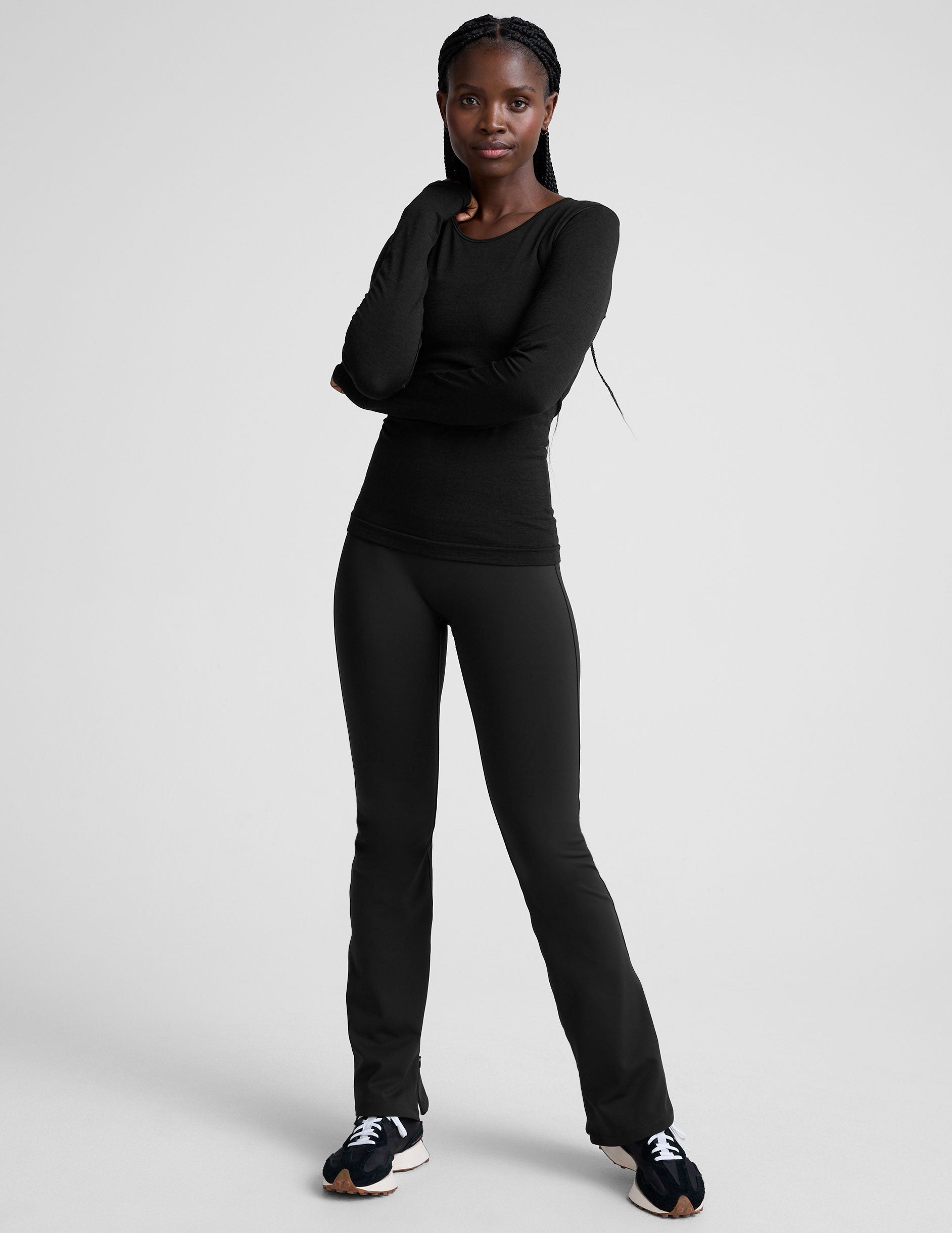 person wearing black high-waisted pants on a white background.