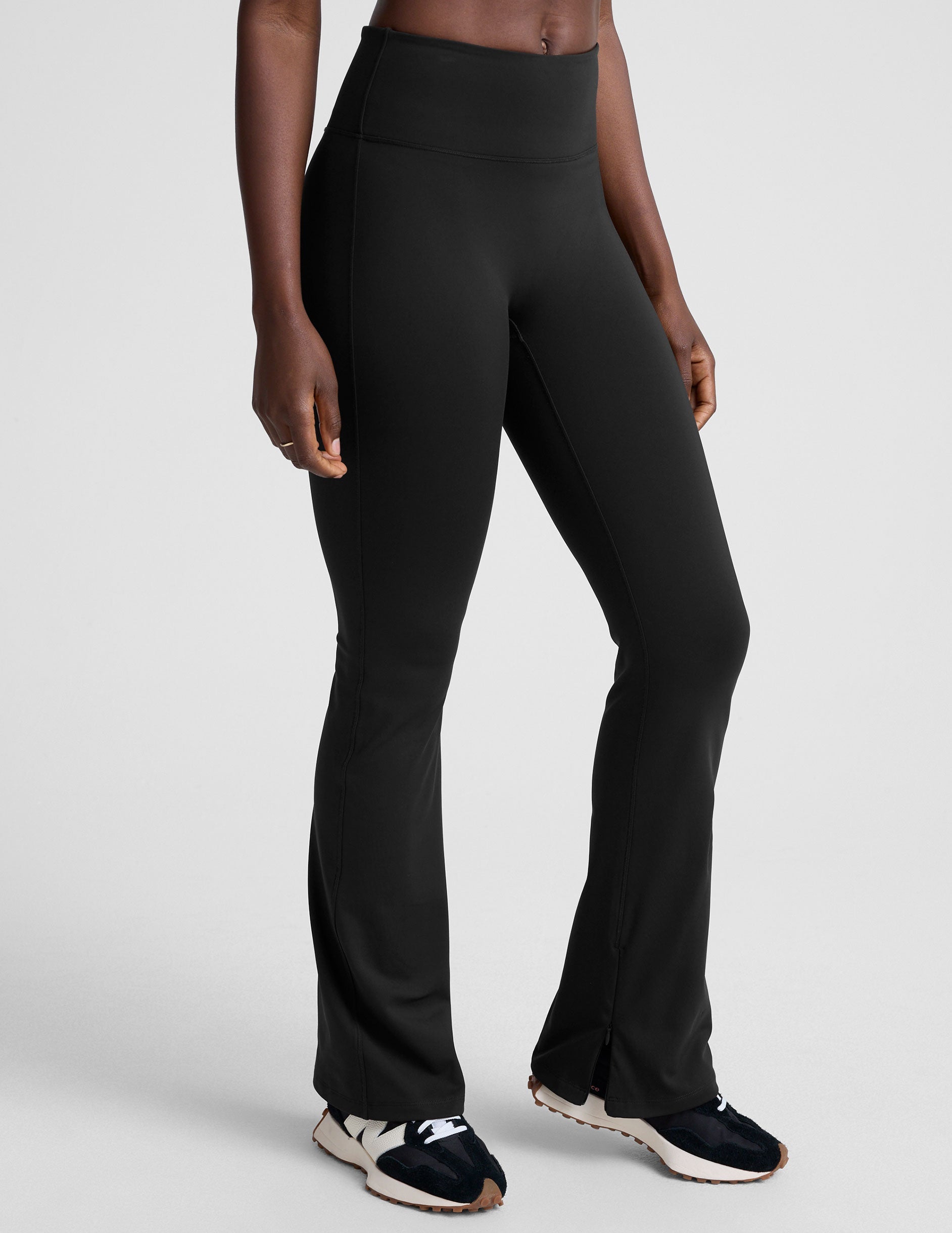 person wearing black high-waisted pants on a white background.
