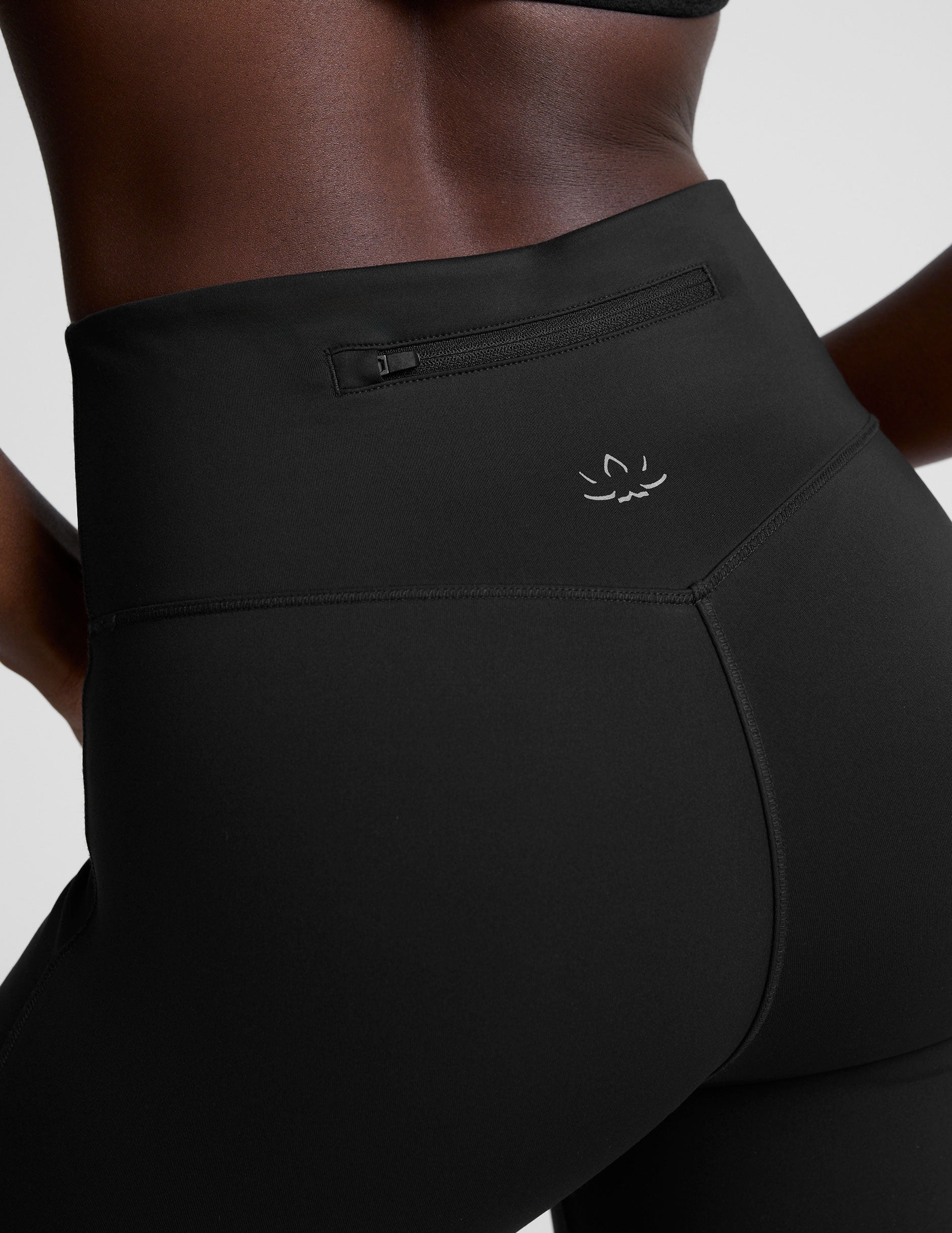 person wearing black high-waisted pants on a white background.