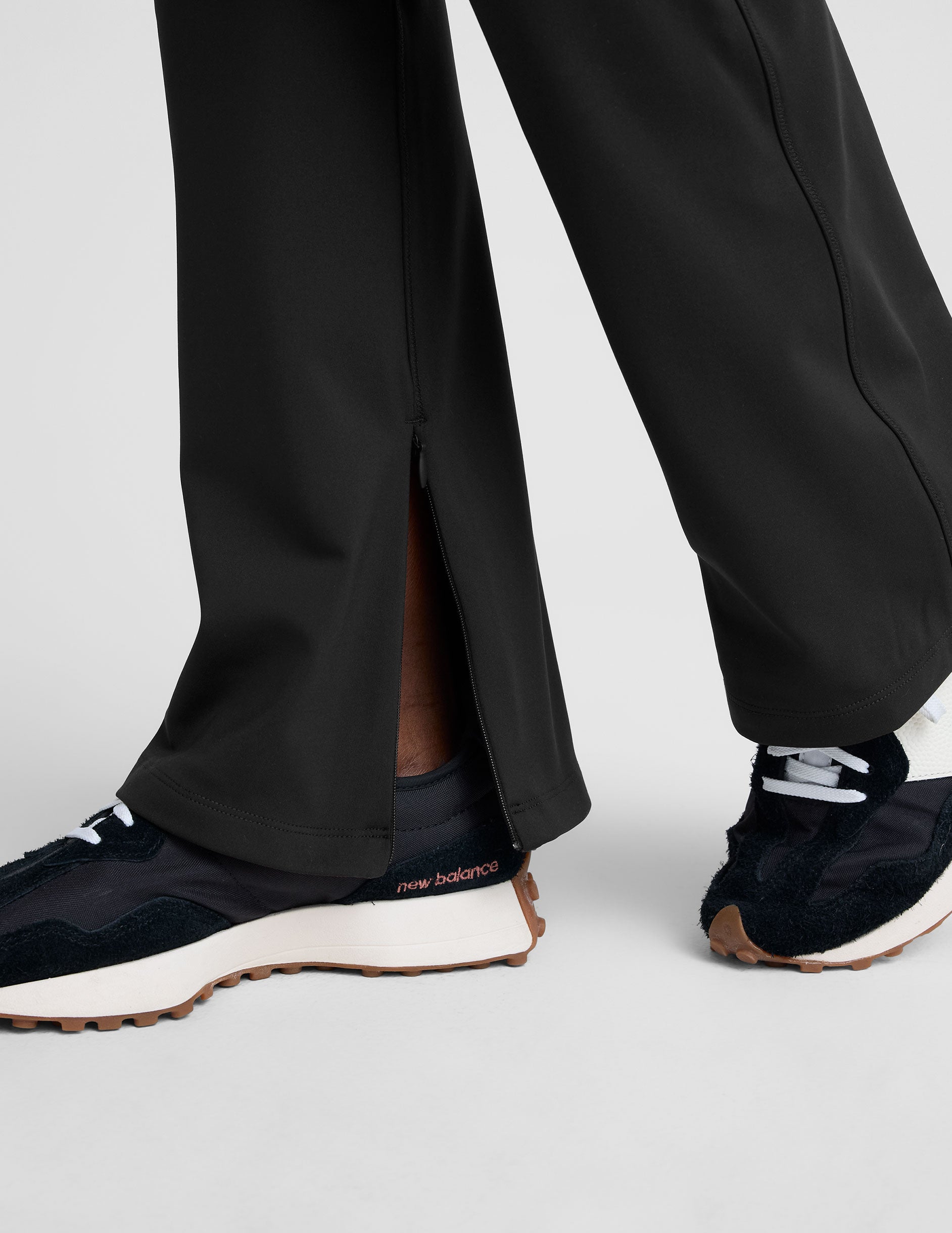 person wearing black high-waisted pants on a white background.