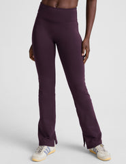 person wearing dark purple pants on a light gray background.
