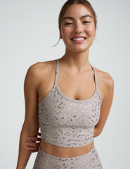 woman in pink mini moon printed cropped tank and leggings against a plain background.