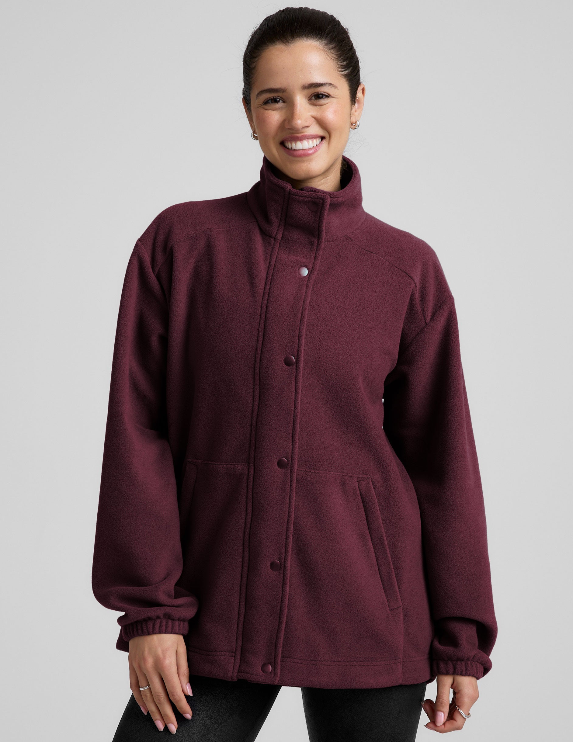 red fleece button up jacket with a full front zip and snap closures and pockets.