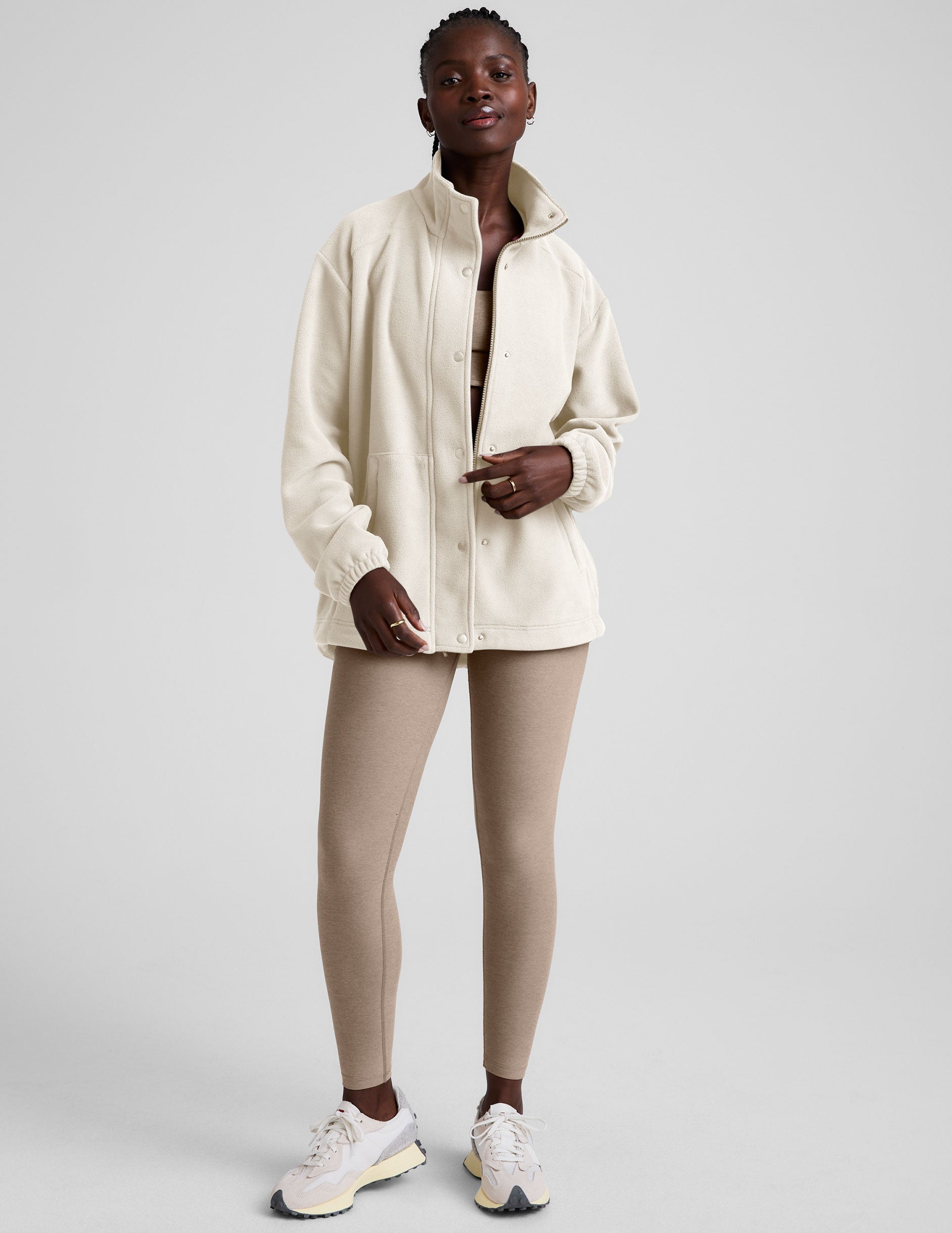 white fleece button up jacket with a full front zip and snap closures and pockets.