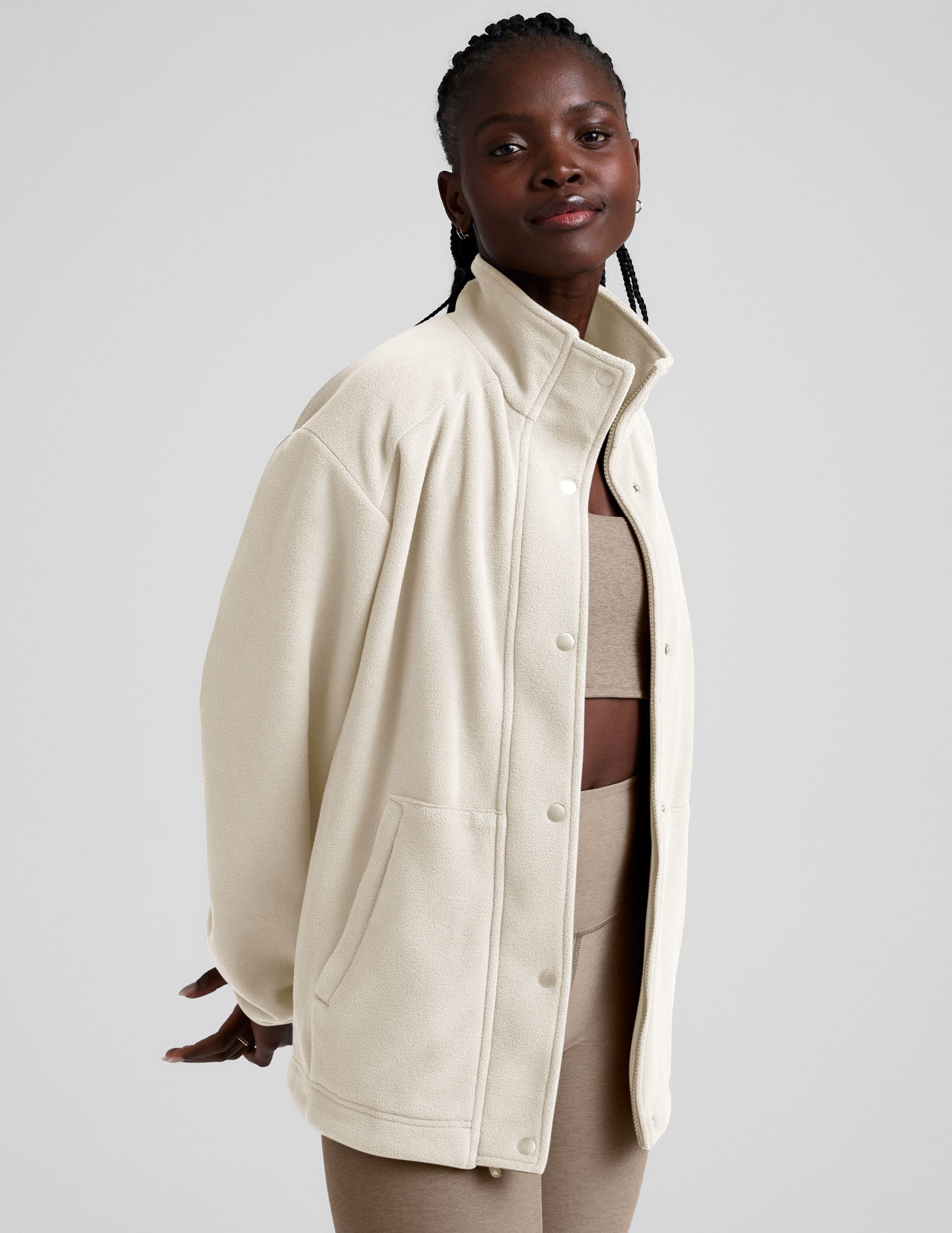 white fleece button up jacket with a full front zip and snap closures and pockets.