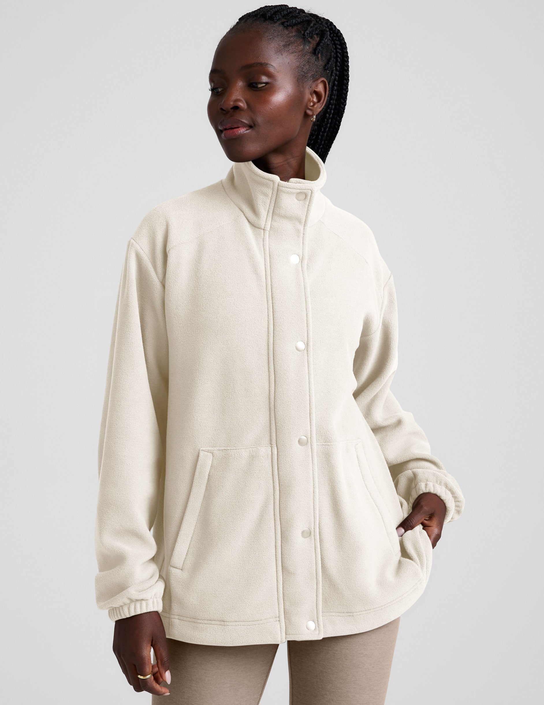 white fleece button up jacket with a full front zip and snap closures and pockets.