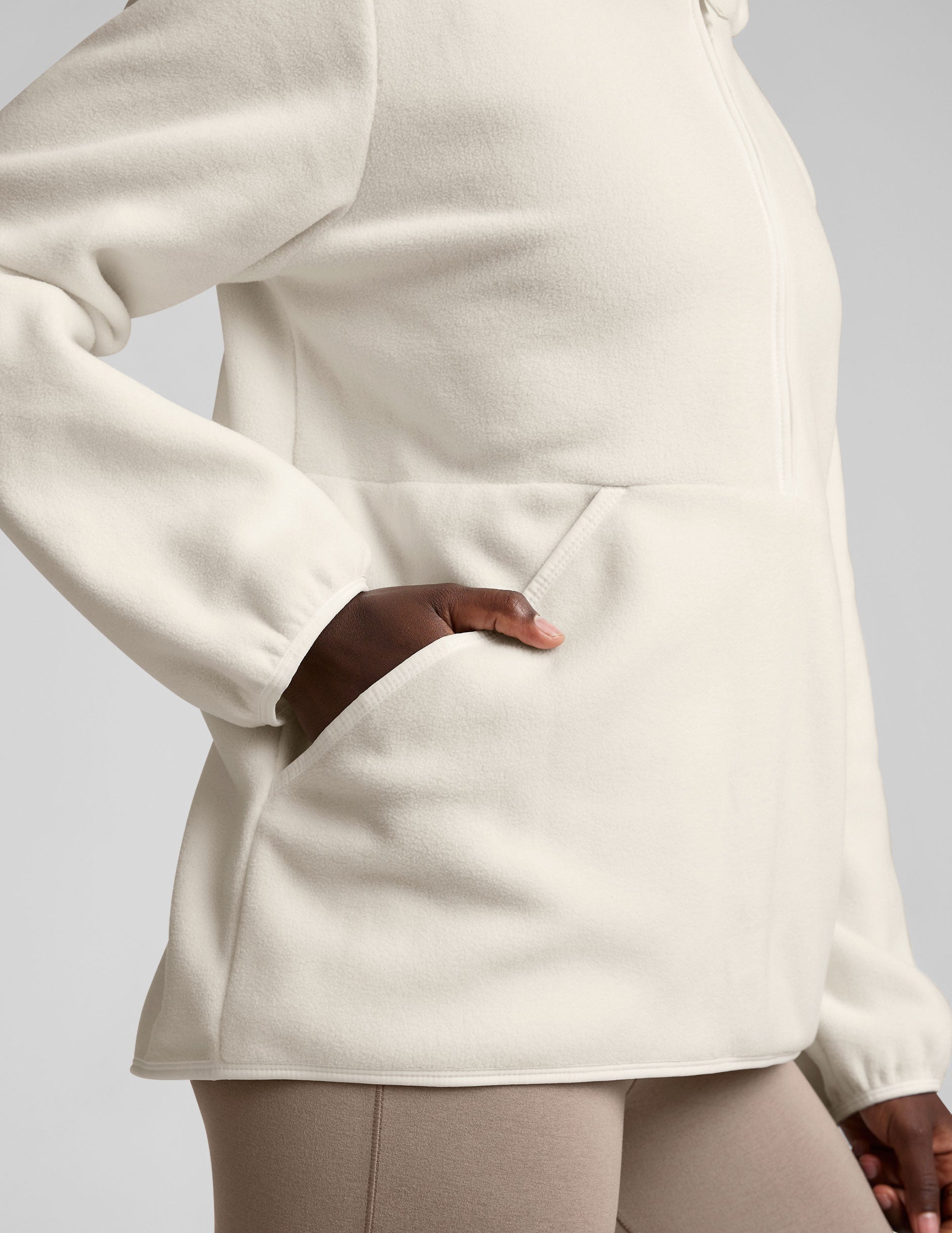 white fleece quarter zip jacket with a kangaroo pocket.