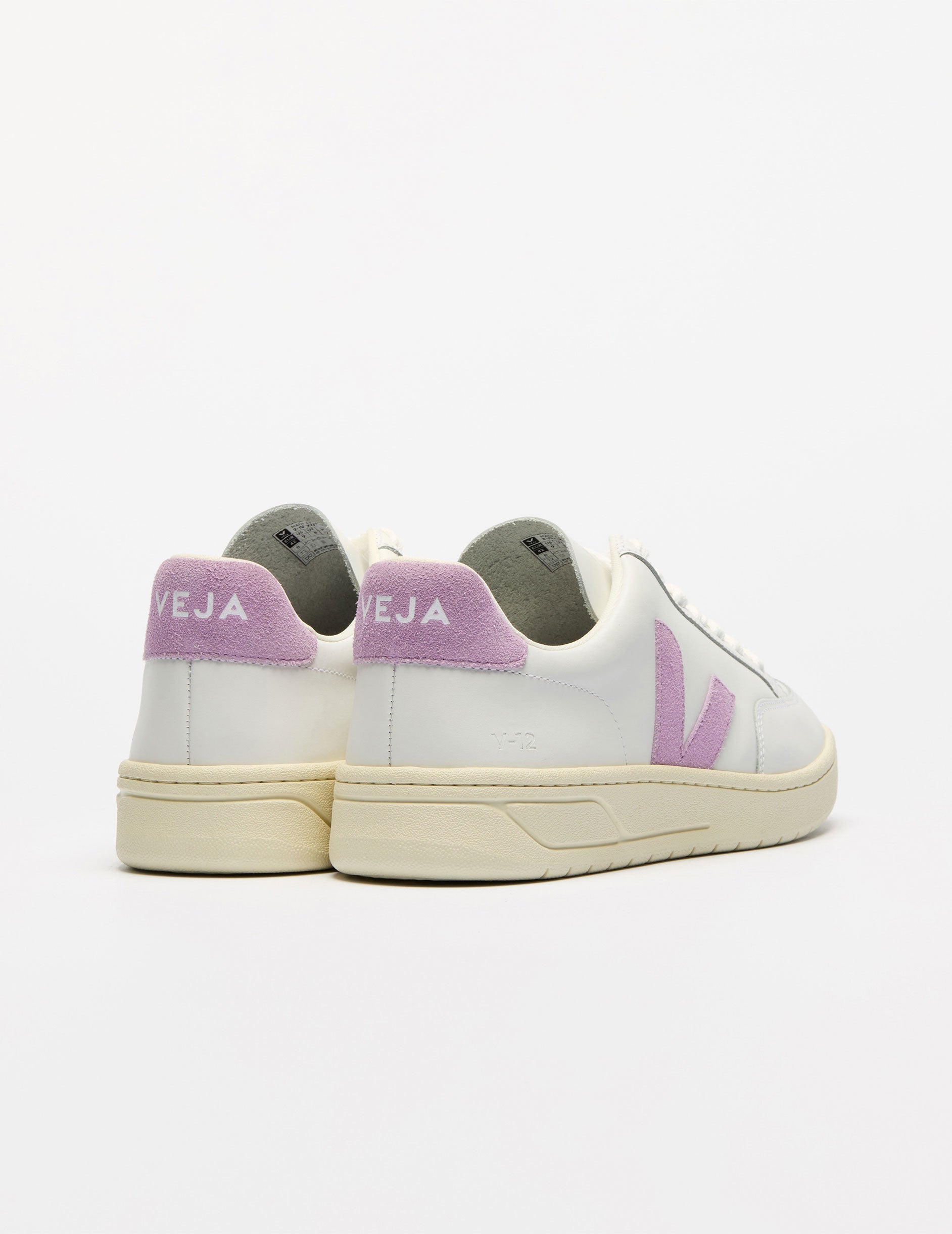 white low top VEJA sneakers with a purple logo detailing.