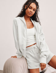 white zip-up jacket with hoodie and pockets.