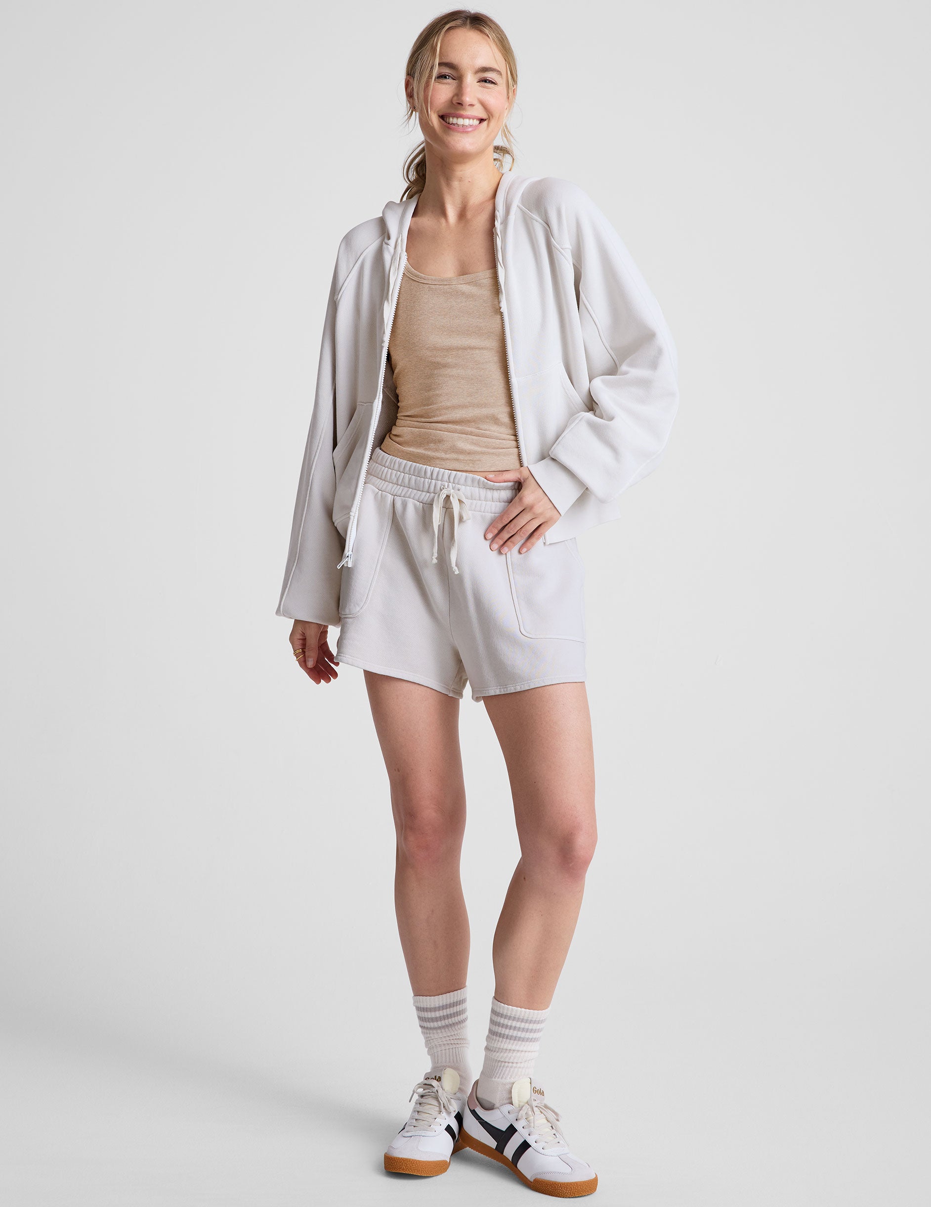 white zip-up jacket with hoodie and pockets.