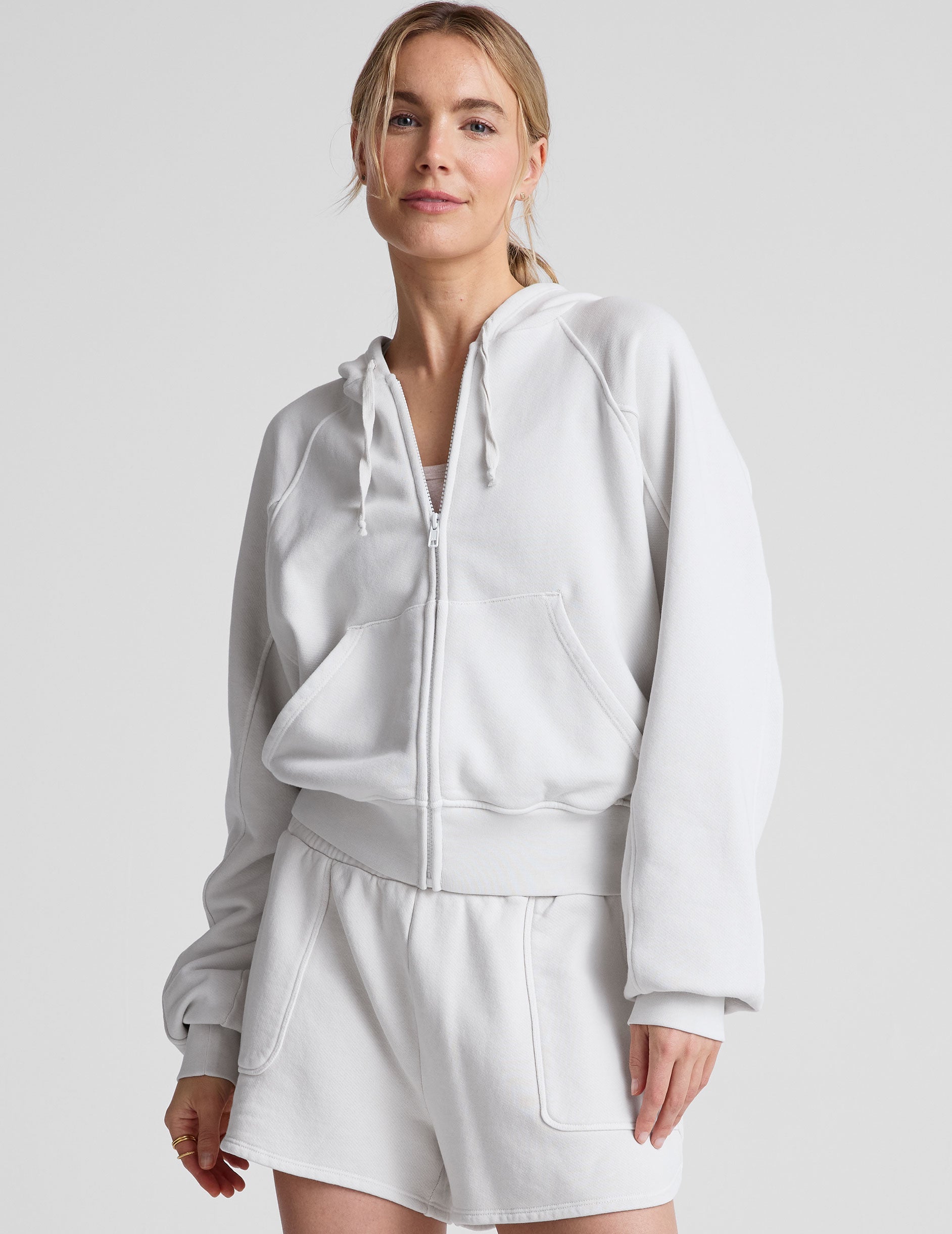 white zip-up jacket with hoodie and pockets.