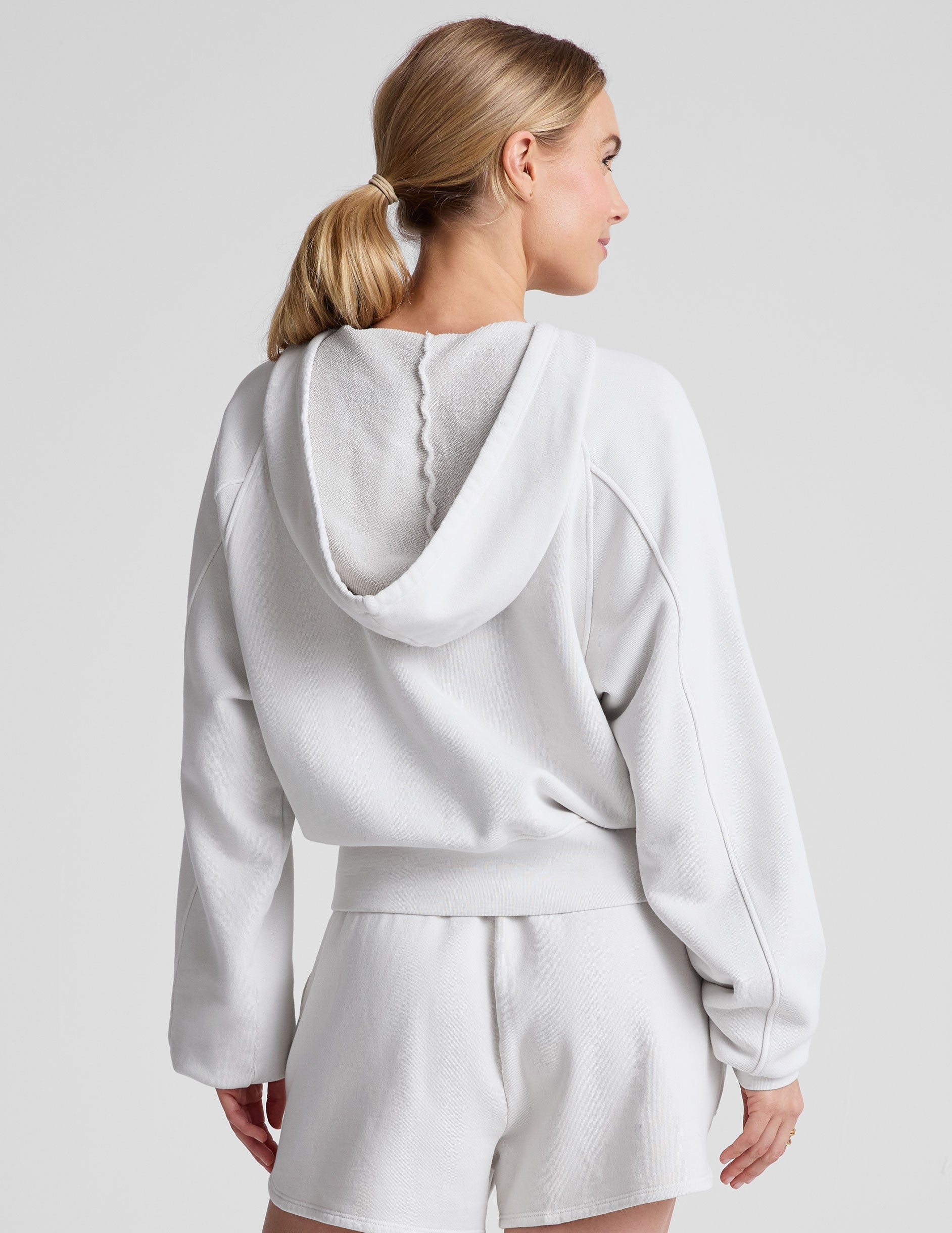 white zip-up jacket with hoodie and pockets.