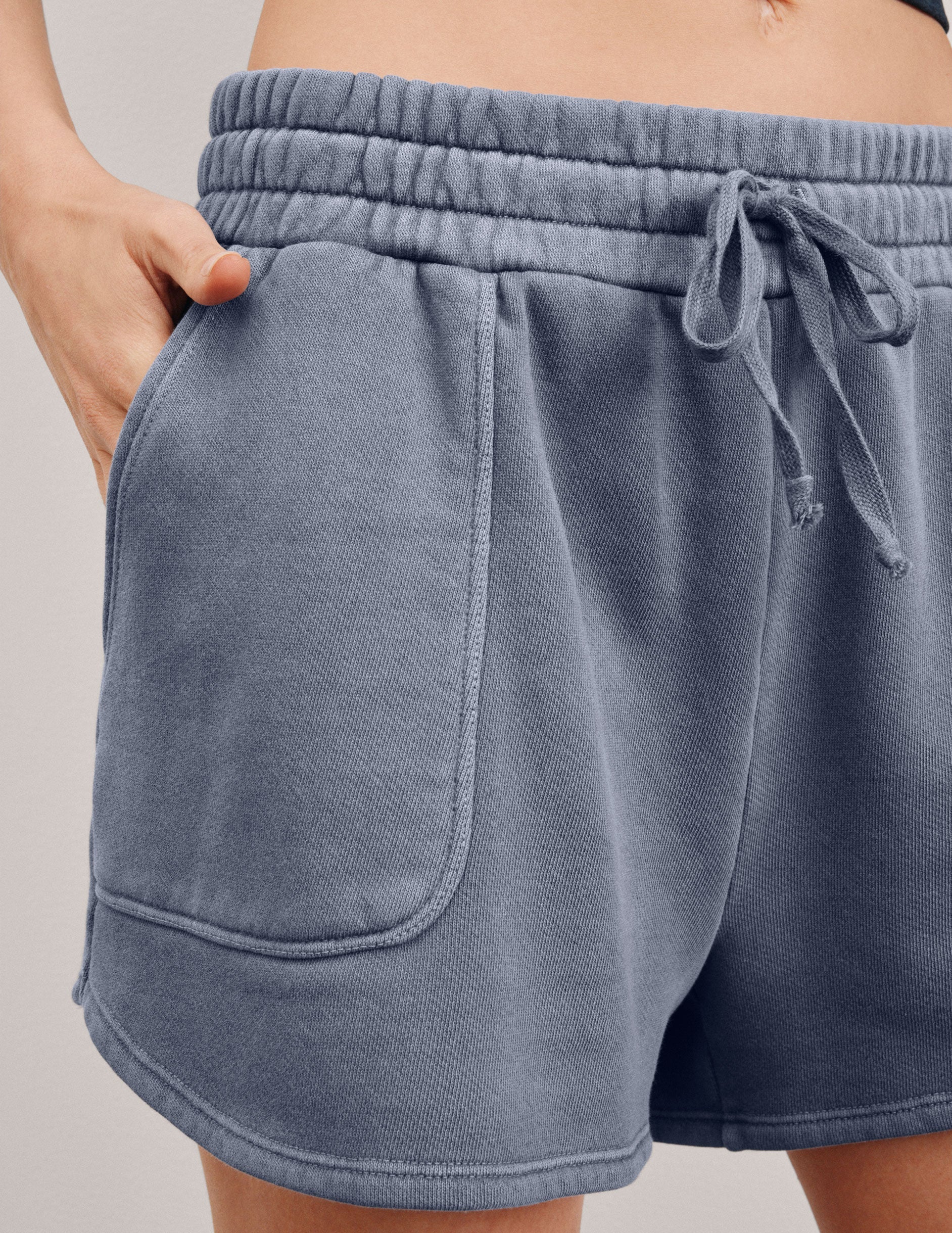 blue shorts with patch pockets and a drawstring at the waistband.