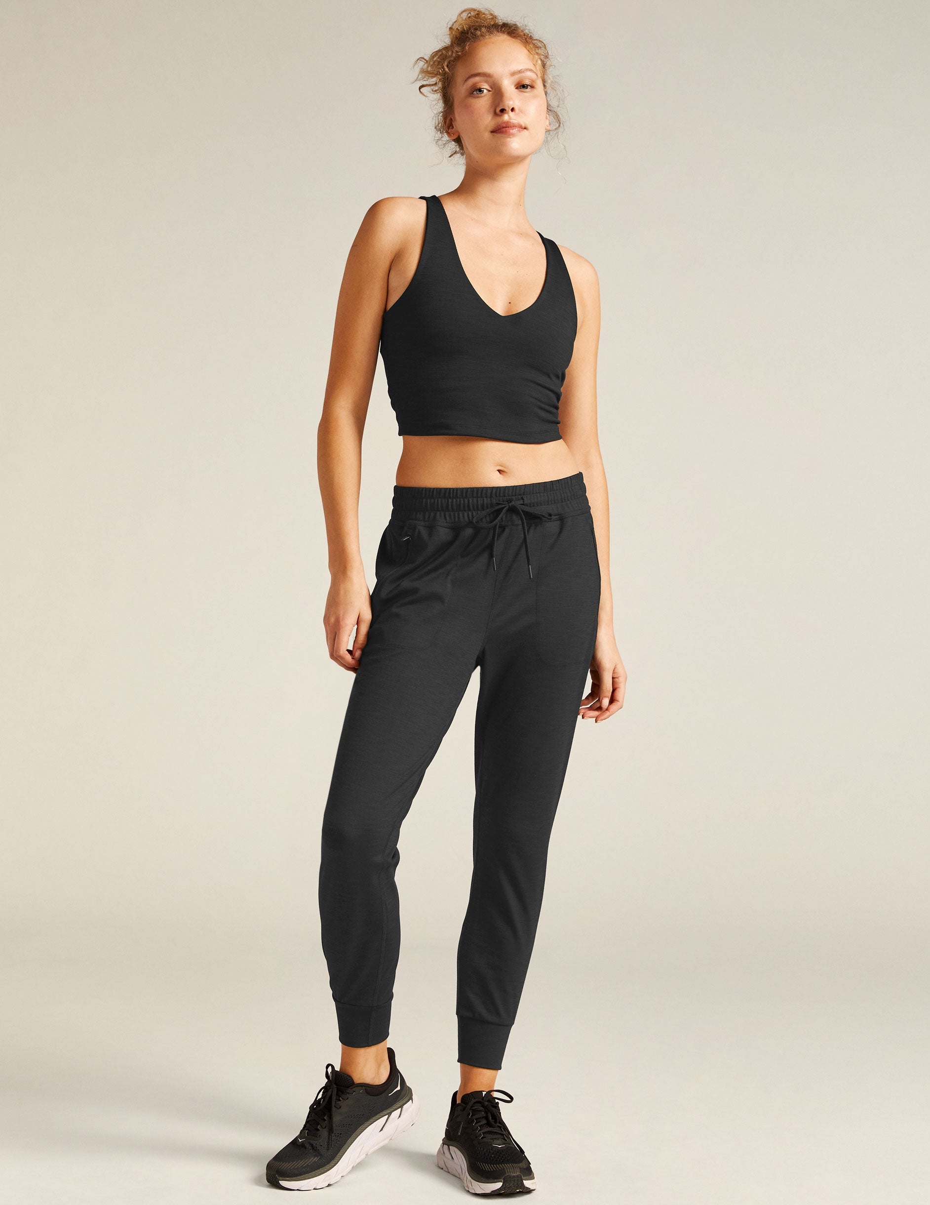 black high-waisted midi joggers with pockets and a drawstring at waistband