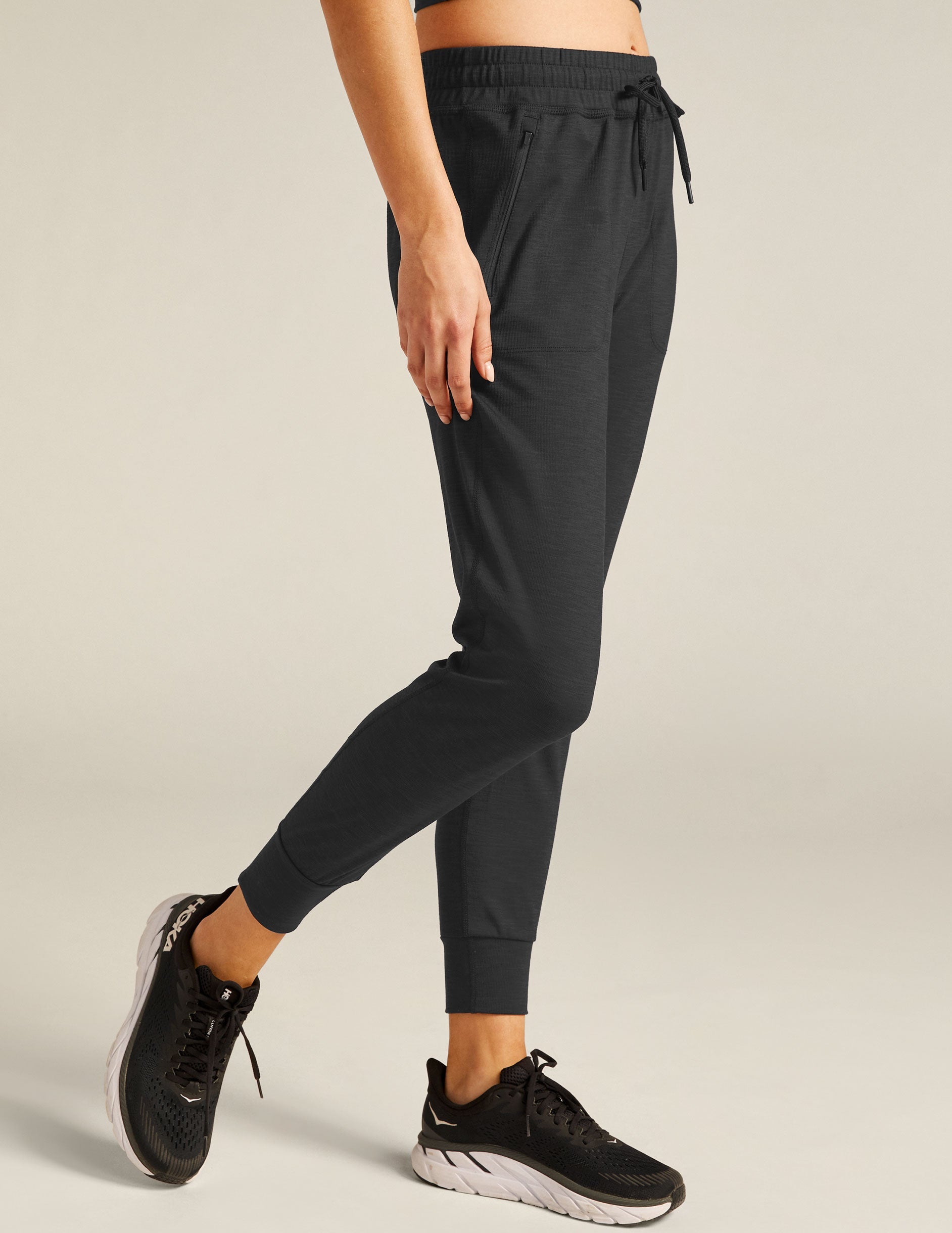 black high-waisted midi joggers with pockets and a drawstring at waistband