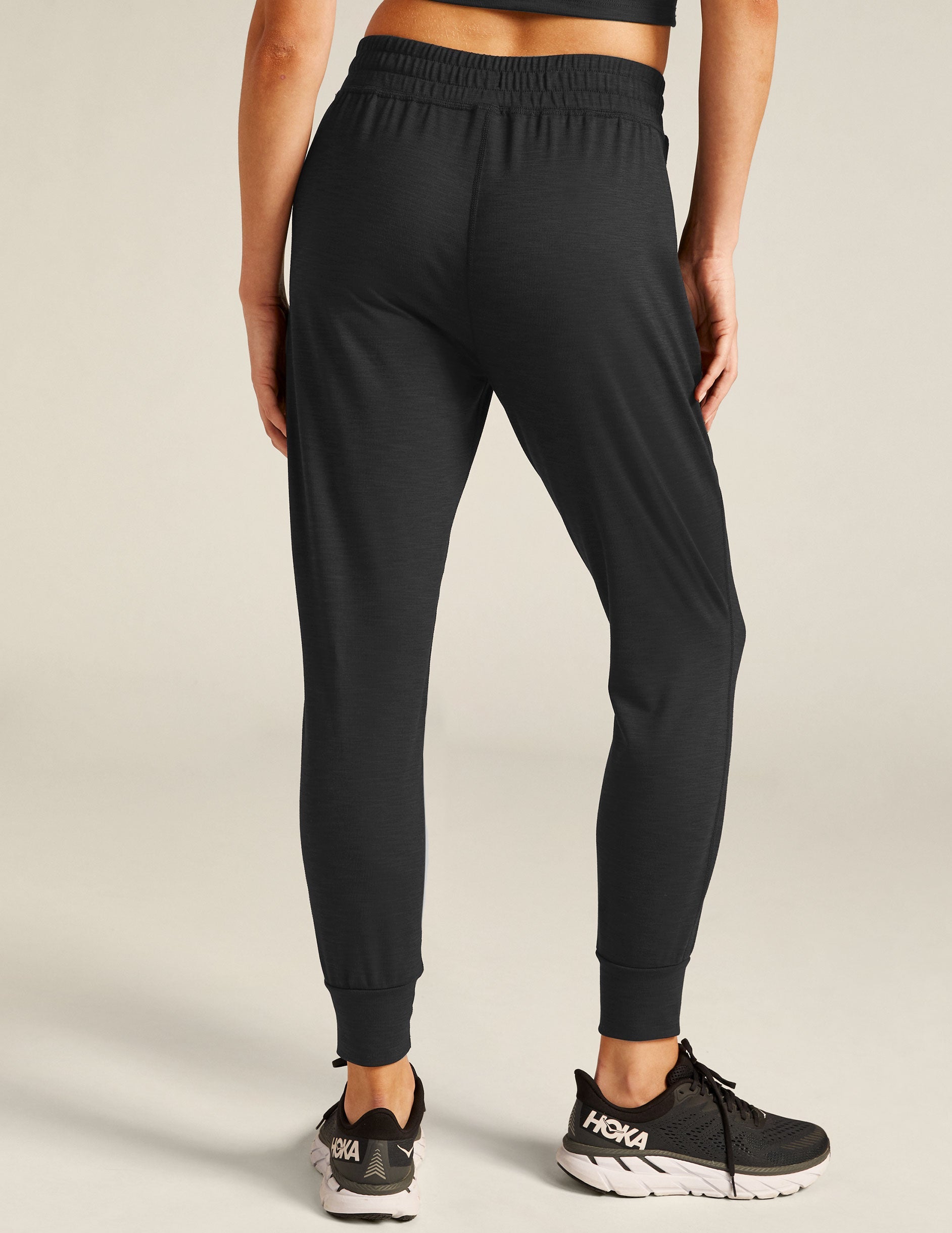 black high-waisted midi joggers with pockets and a drawstring at waistband