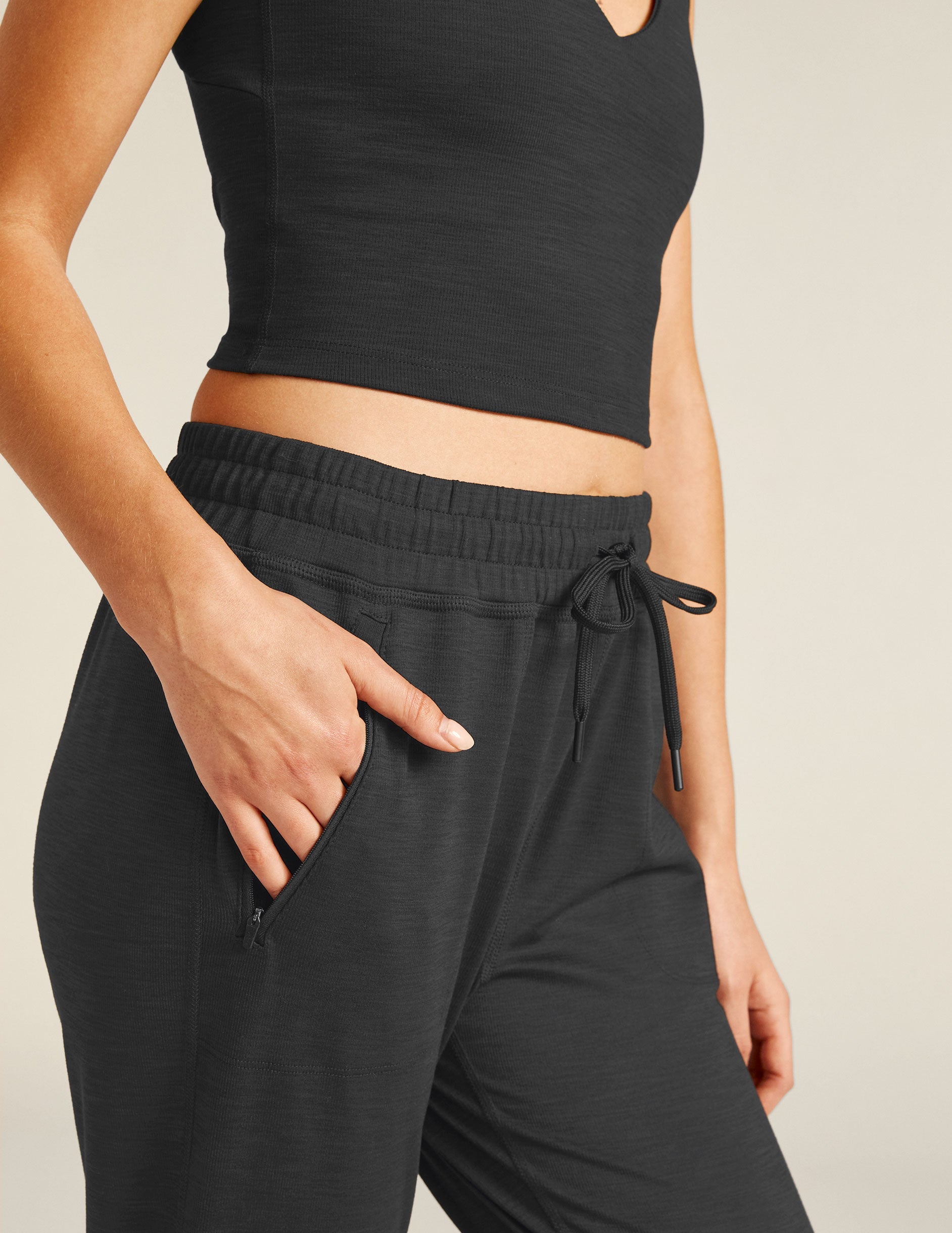 black high-waisted midi joggers with pockets and a drawstring at waistband