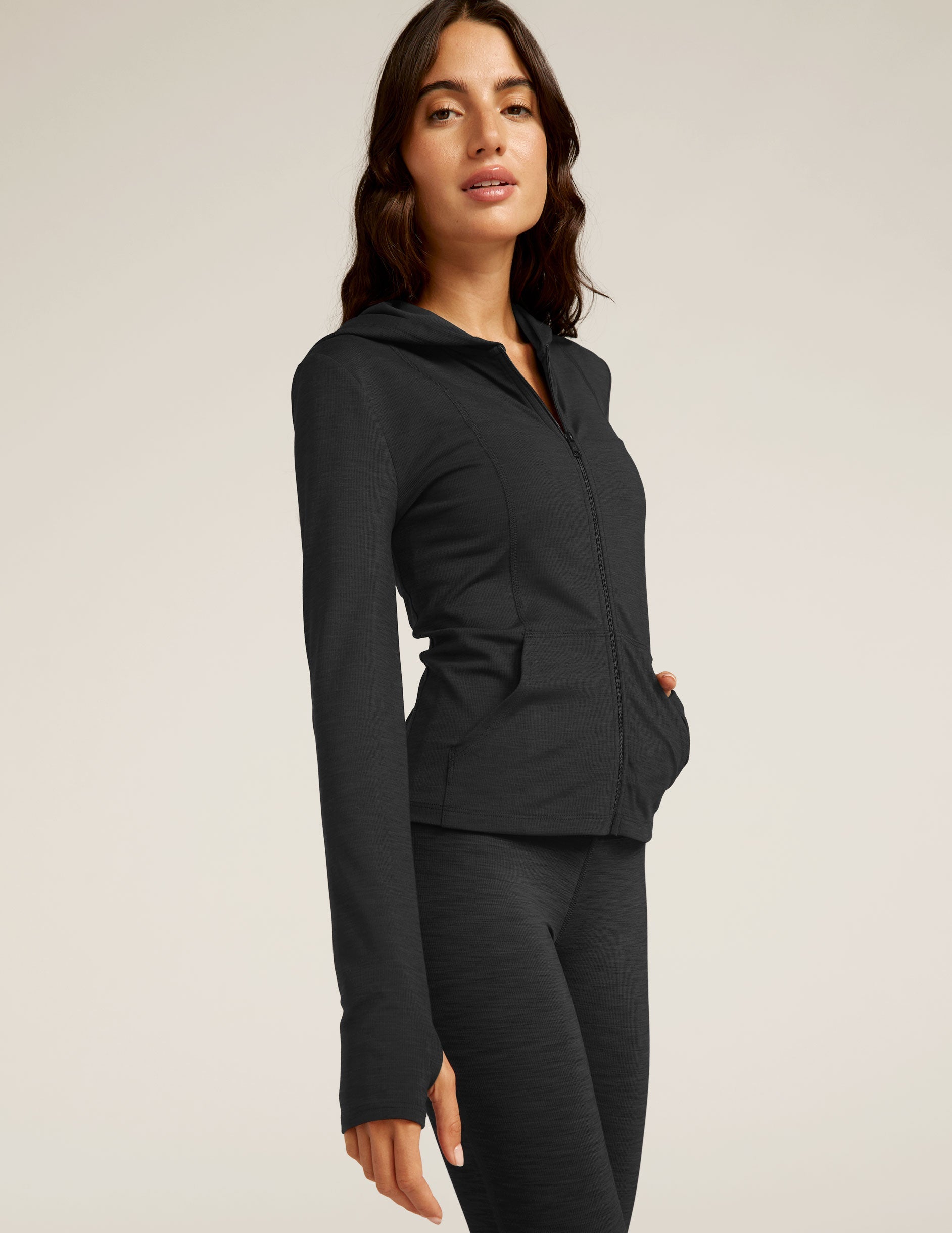 black zip-up jacket with a hoodie and thumb holes.