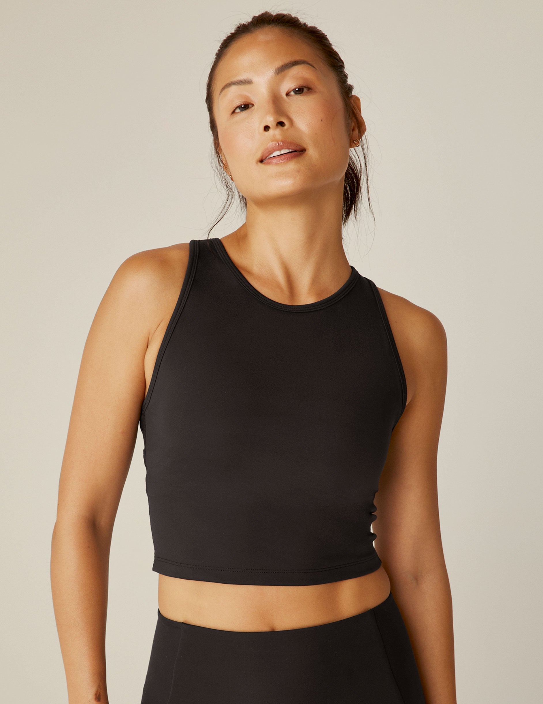 black scoop neck cropped tank with an open back detail held with bartacks.