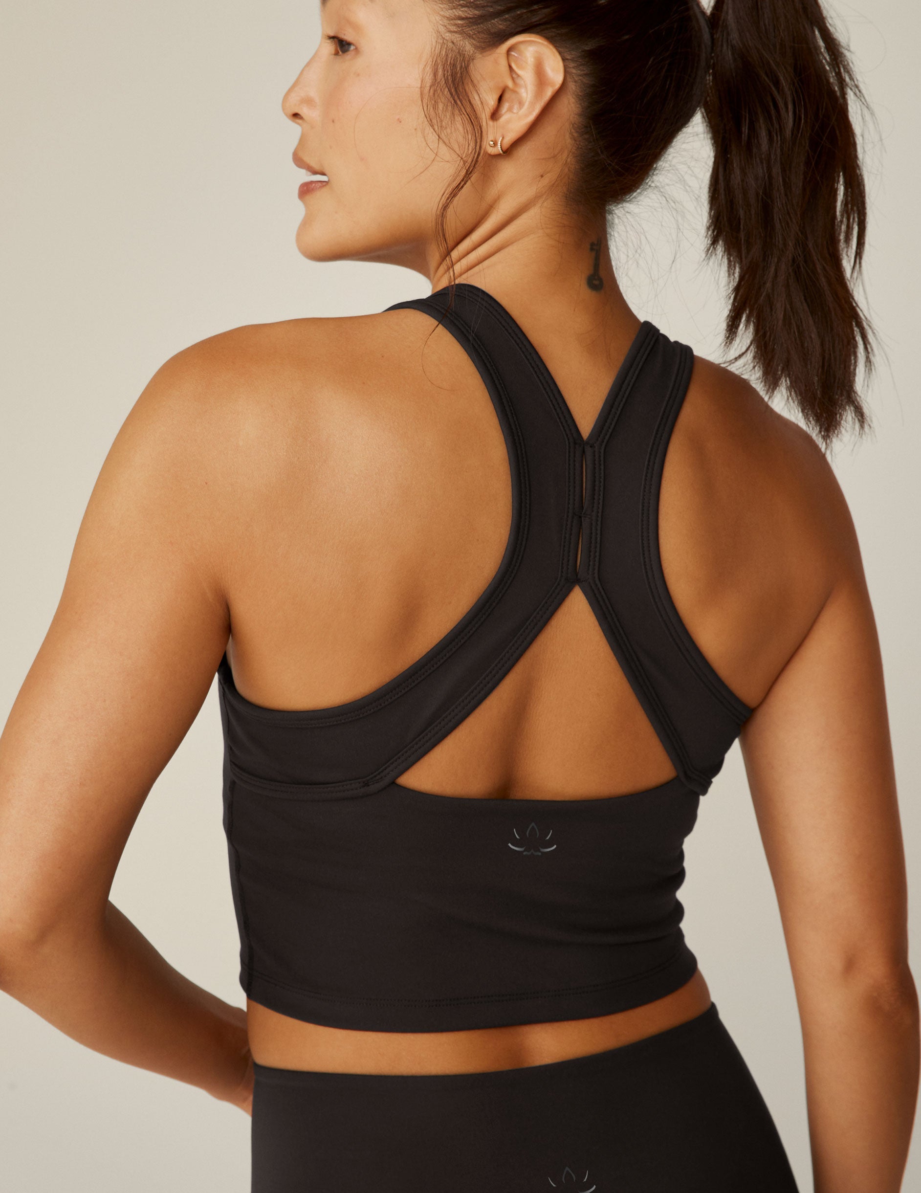 black scoop neck cropped tank with an open back detail held with bartacks.