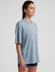 model wearing a light blue oversized cotton t-shirt and navy blue biker shorts against a plain background.