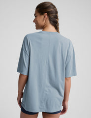 model wearing a light blue oversized cotton t-shirt and navy blue biker shorts against a plain background.